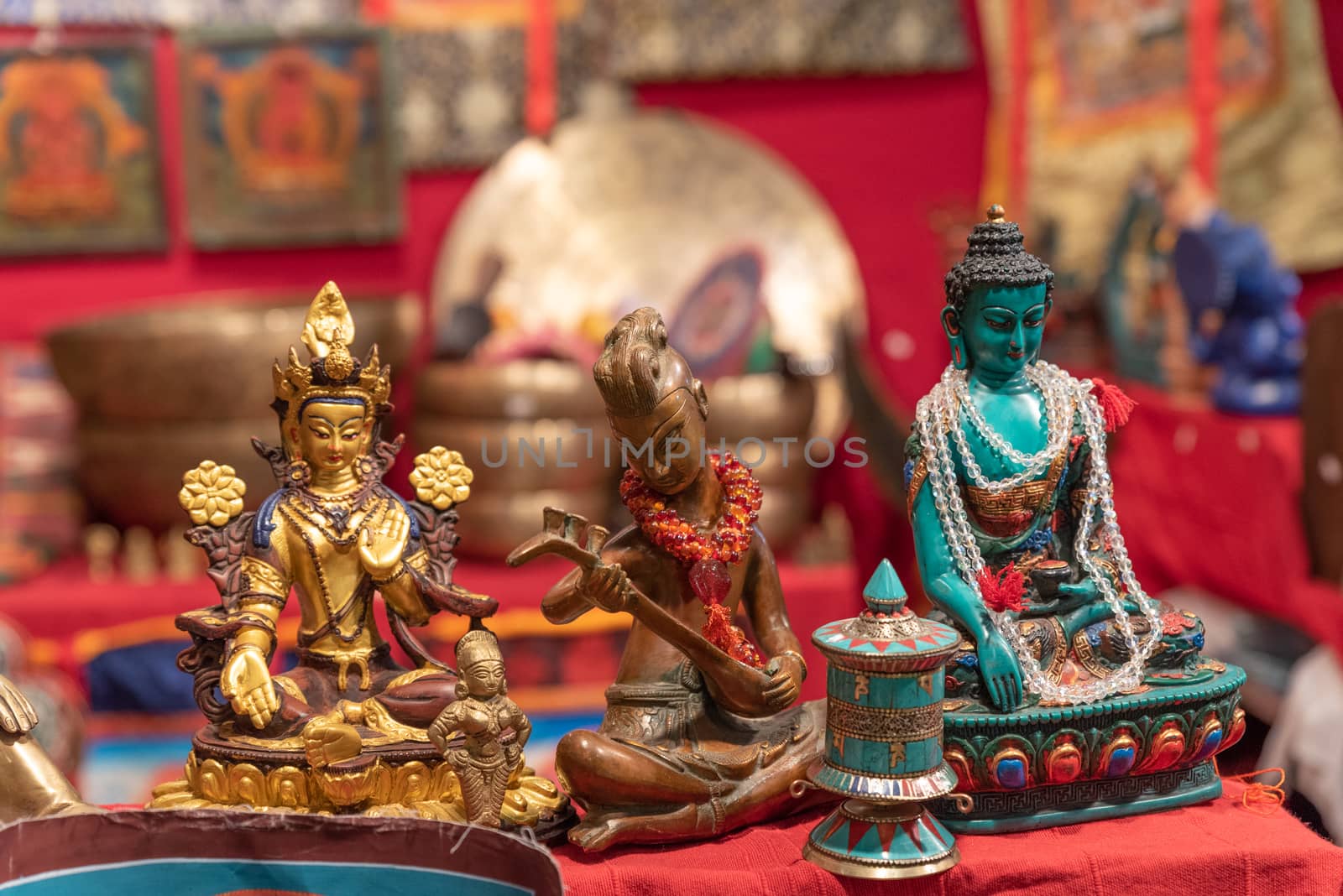 Three different statuettes depicting the Buddha in an ethnic market, horizontal image