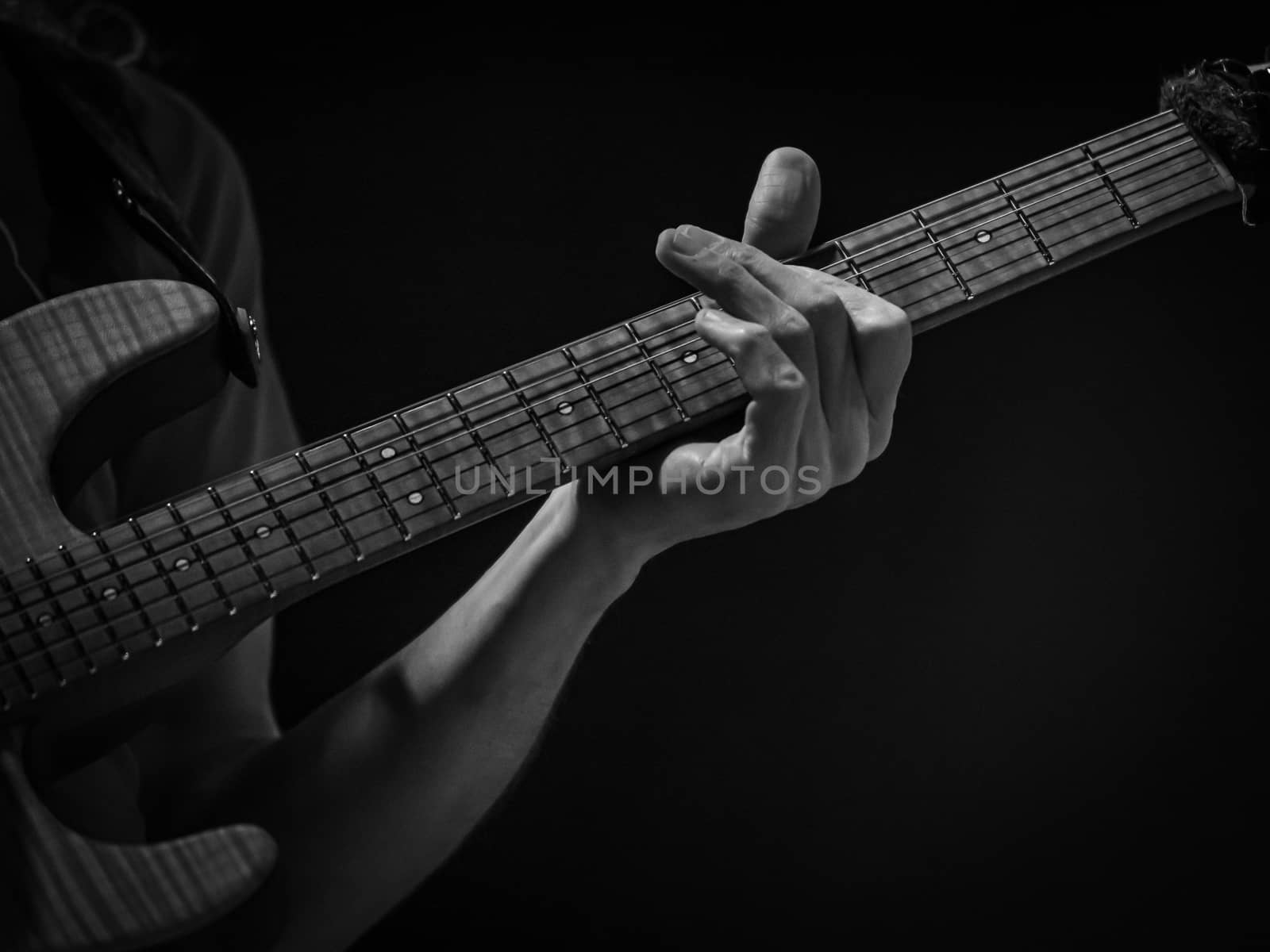 detail of hand playing an electric guitar, black and white image