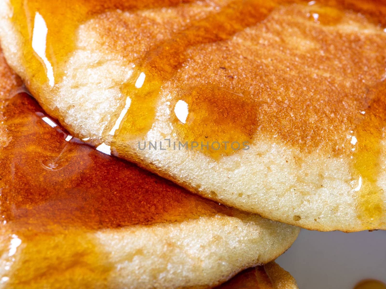 Detail of homemade pancakes wet with maple syrup, food photography