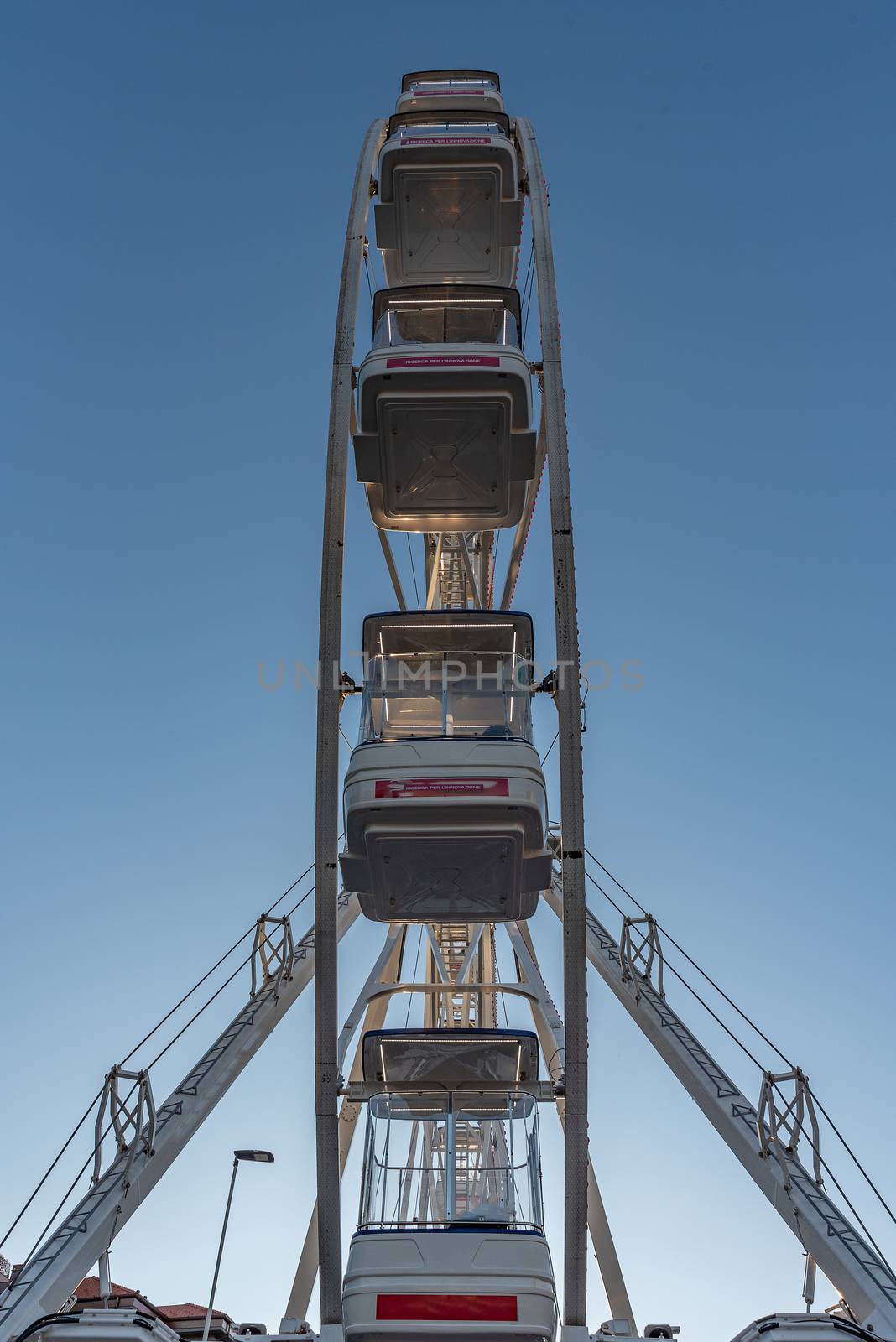 Side view of a Ferris wheel under a blue sky