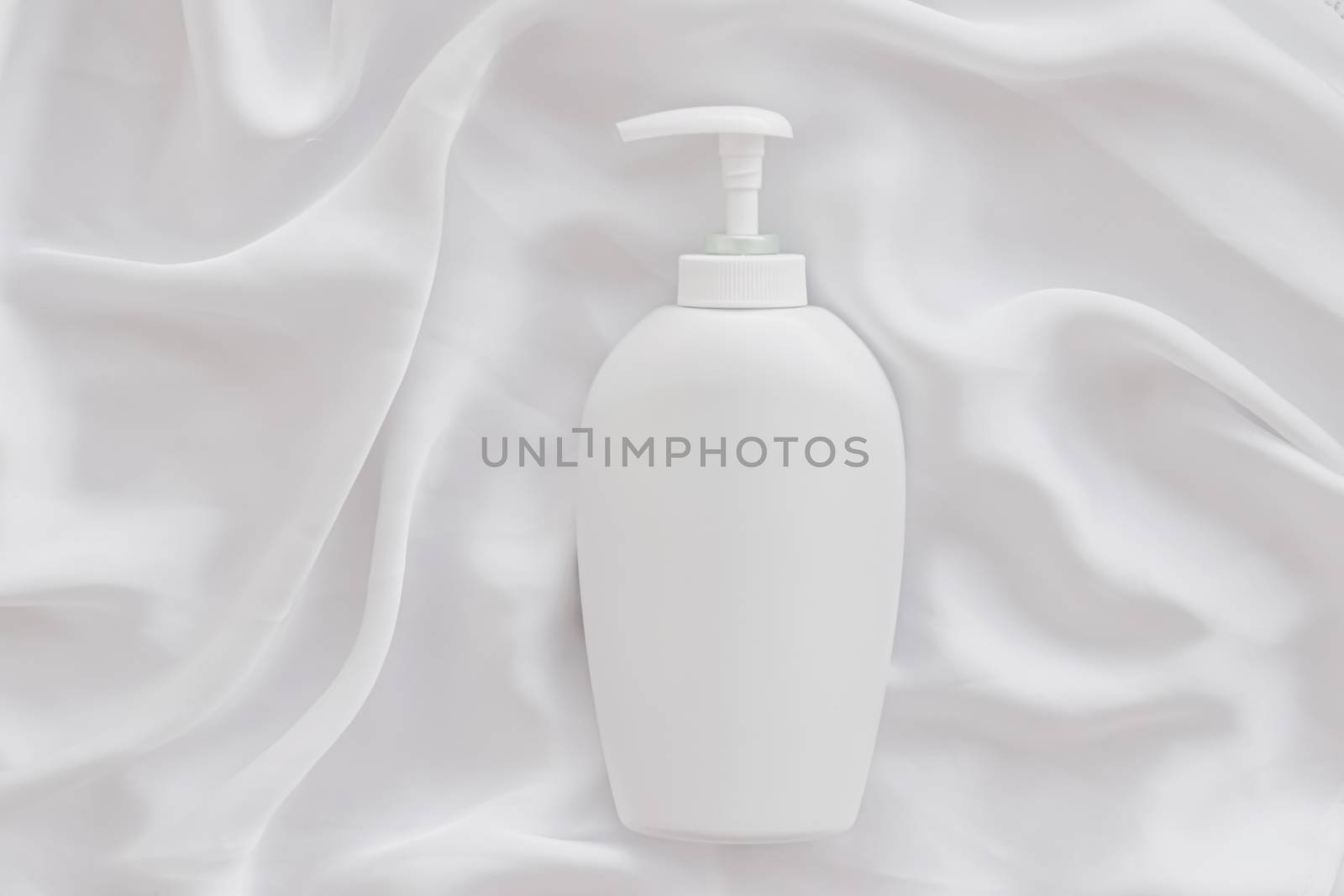 Blank label cosmetic container bottle as product mockup on white silk background, hygiene and healthcare