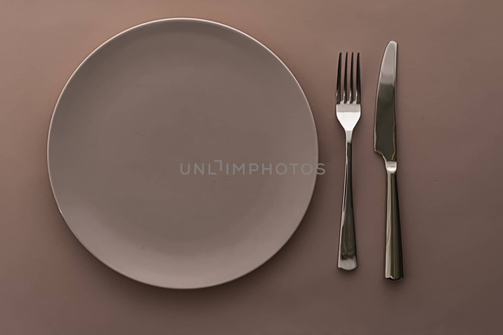 Empty plate and cutlery as mockup set on brown background, top tableware for chef table decor and menu branding design