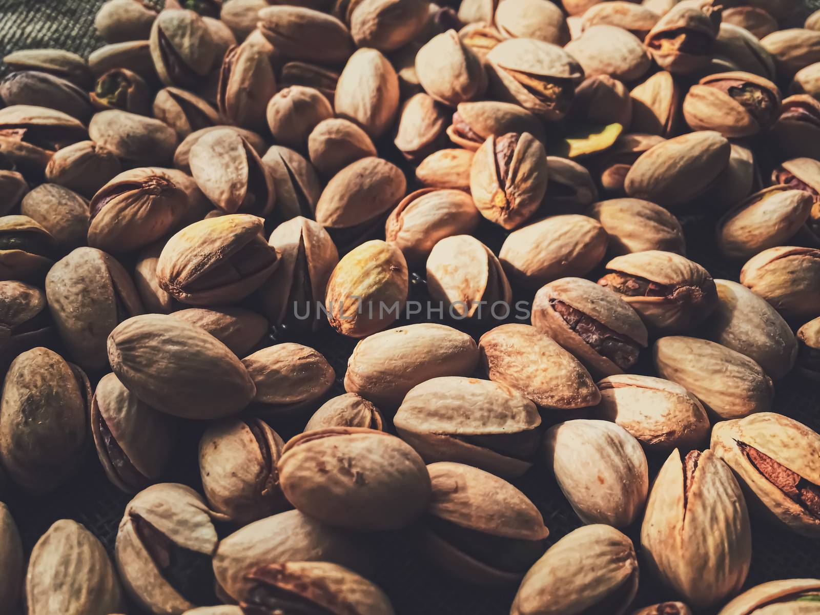 Pistachio nuts on rustic linen background, food and nutrition