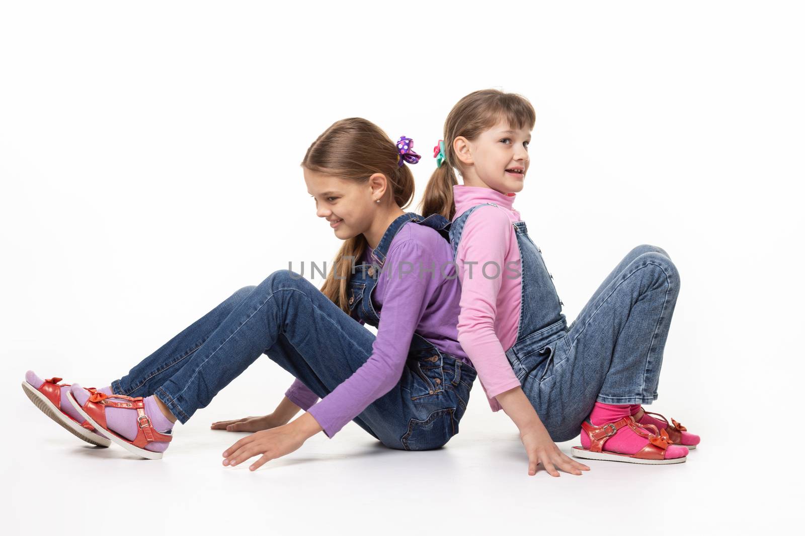 Children sitting on the floor pushing their backs