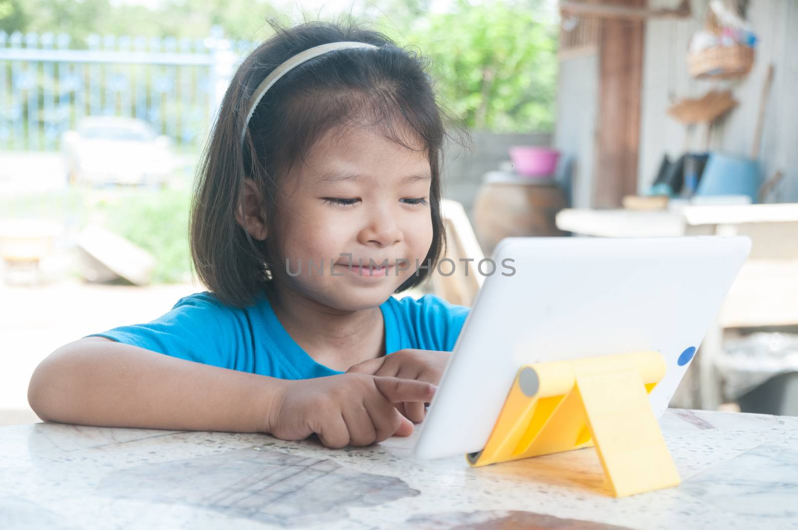 Asian Girl learning online course or playing game online at home by thampapon