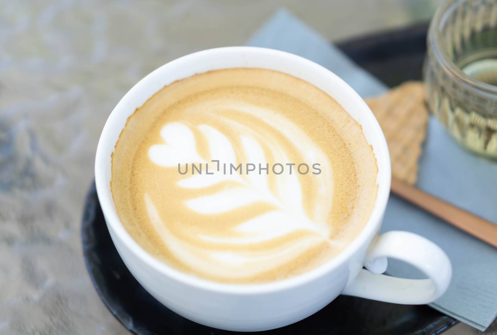 Closeup glass of latte art coffee tulip shape on wood background with vintage color, selective focus