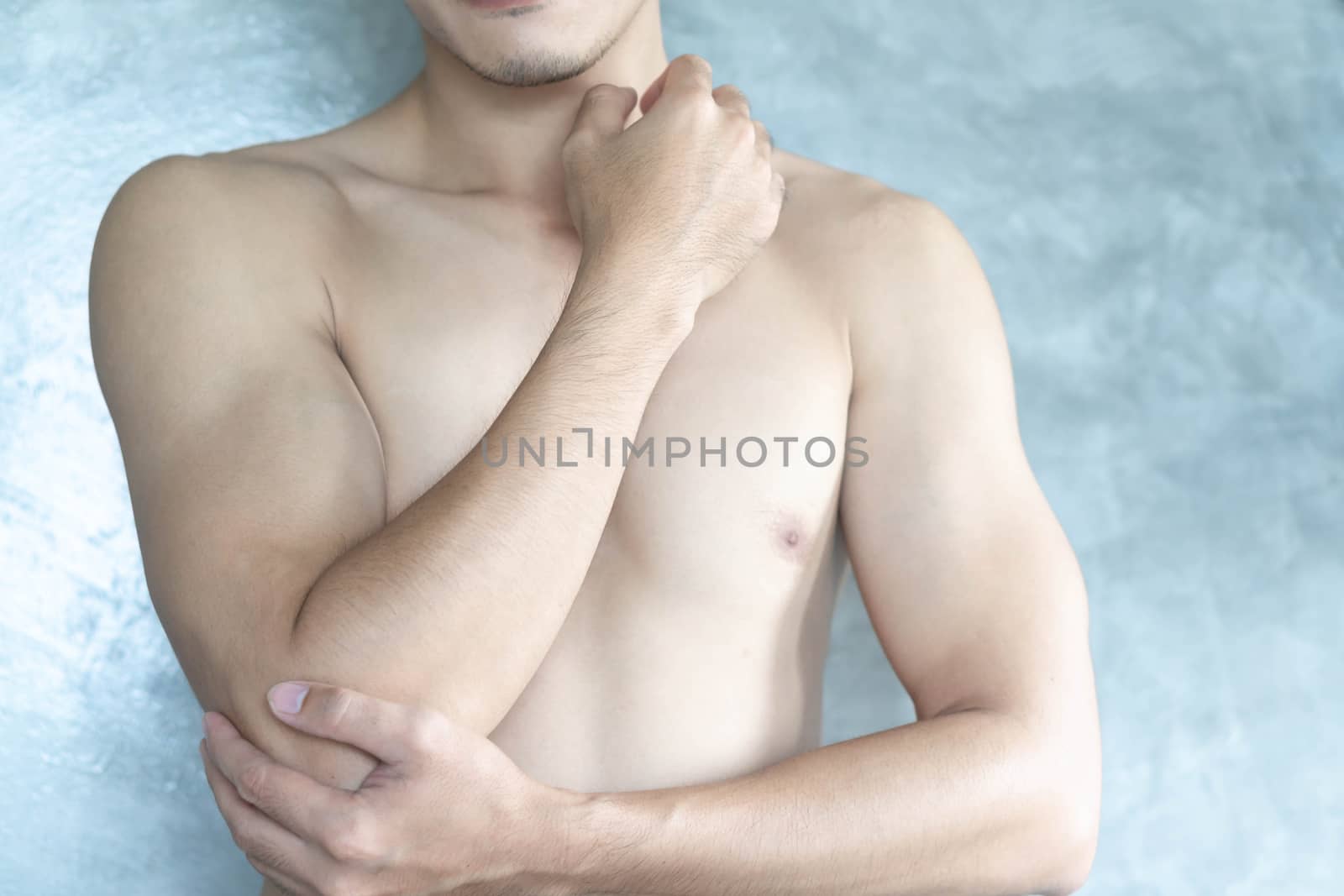 Closeup man hand holding elbow with pain with grey background, health care and medical concept