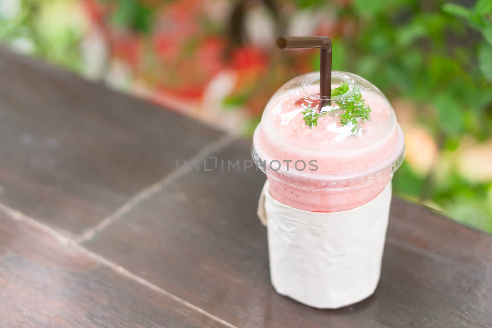 Closeup  strawberry smoothie with green nature background, selective focus