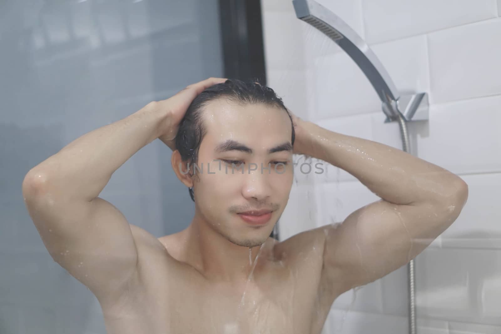 Closeup young man washing hair with with shampoo in the bathroom, vintage tone, selective focus