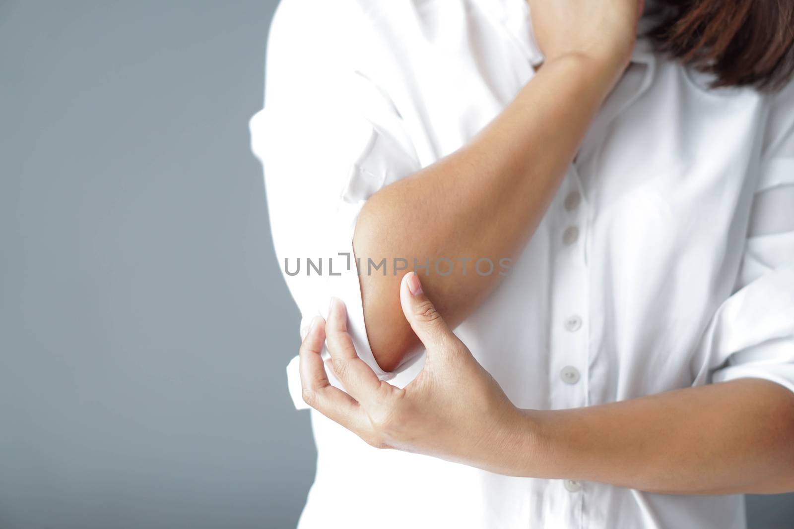 Closeup woman hand holding elbow with pain lying on bed, health care and medical concept