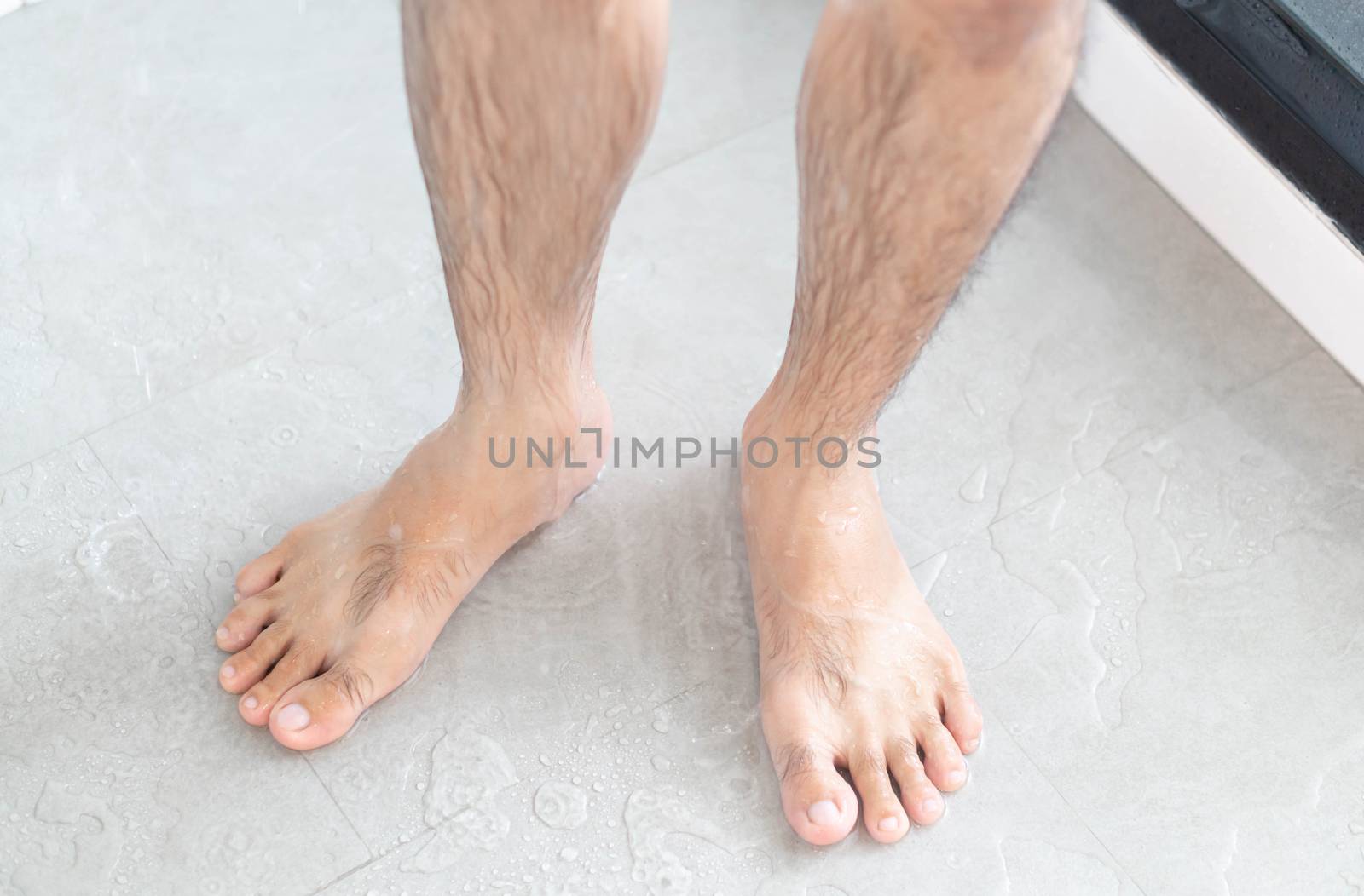 Close up man legs with taking a shower in the bathroom, health care and beauty
