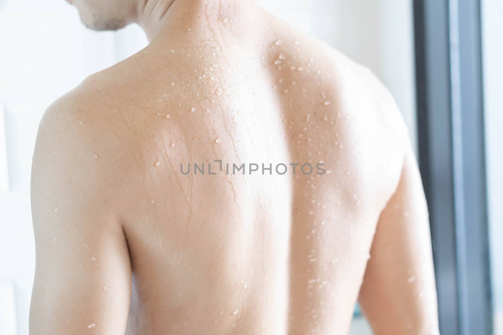 Closeup back of handsome asian man taking a shower in the bathro by pt.pongsak@gmail.com