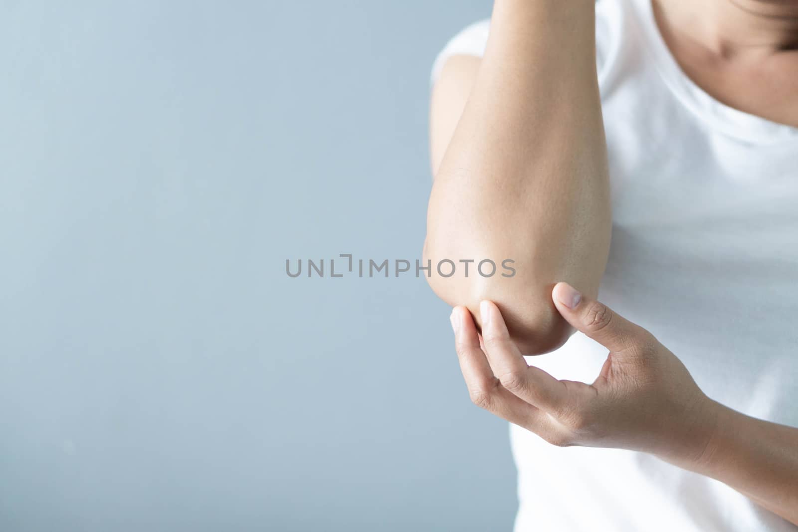 Closeup woman hand holding elbow with pain lying on bed, health care and medical concept