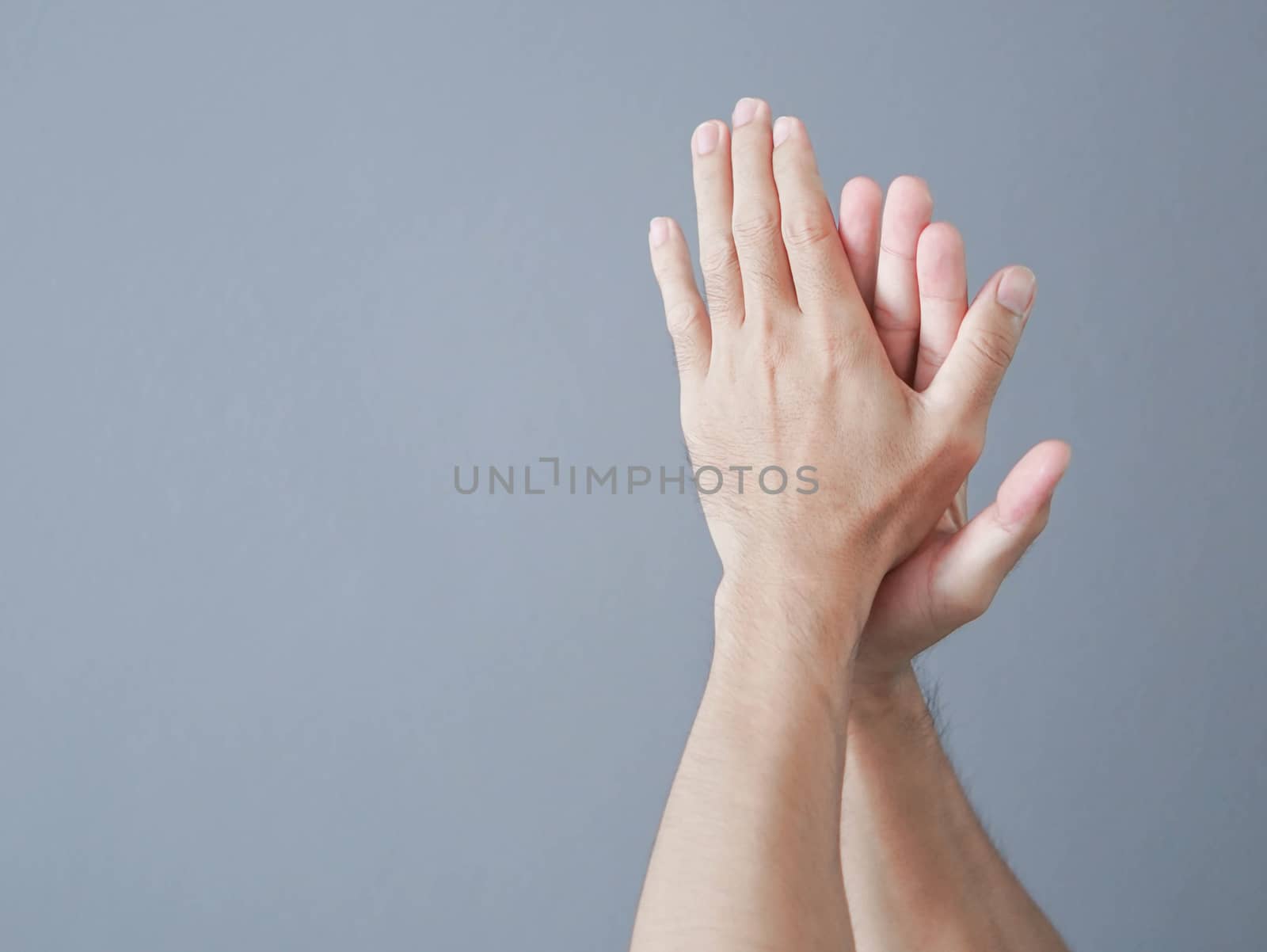 Man clapping hands on grey background