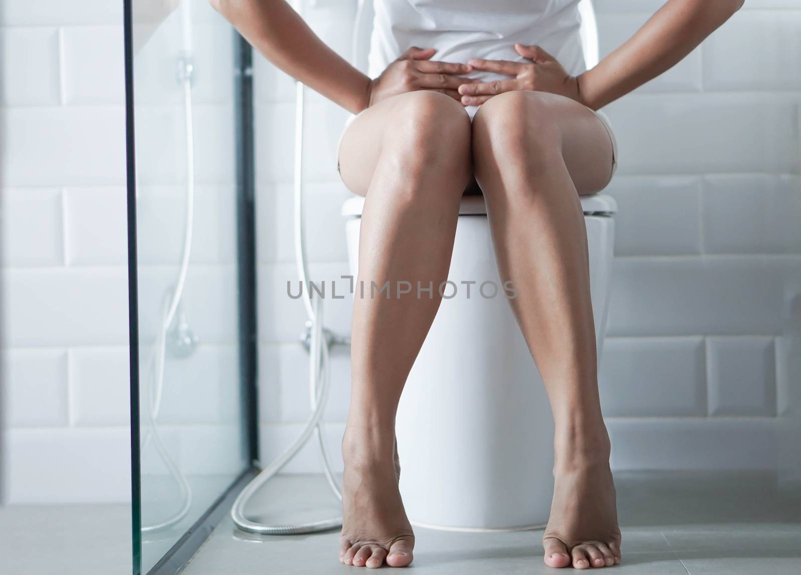 Closeup woman sitting on toilet in the morning, selective focus