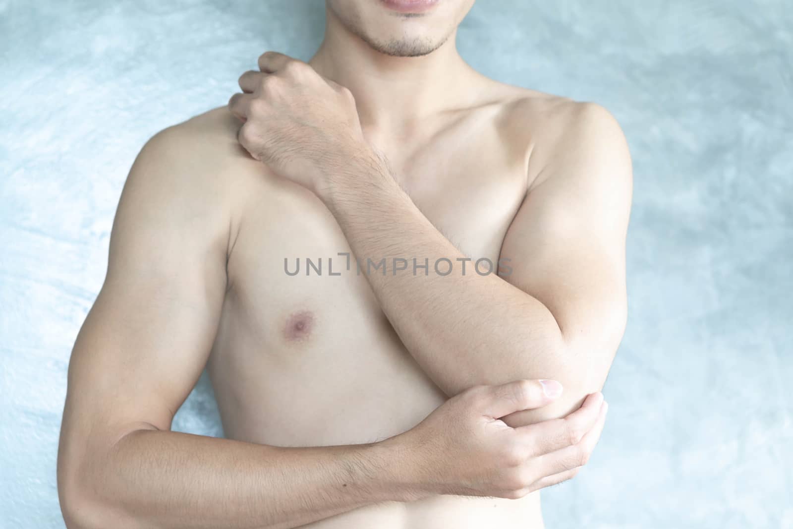 Closeup man hand holding elbow with pain with grey background, health care and medical concept