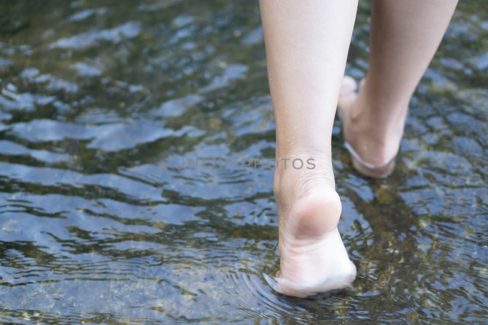 Woman feet walking on the water in the river for relax feeling by pt.pongsak@gmail.com