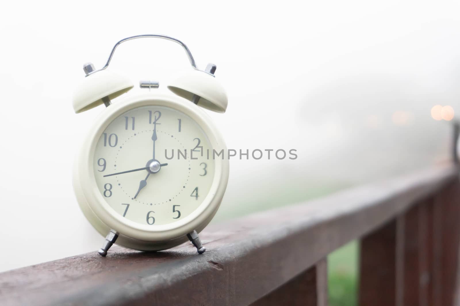 Alarm clock with nature and fog background in the morning