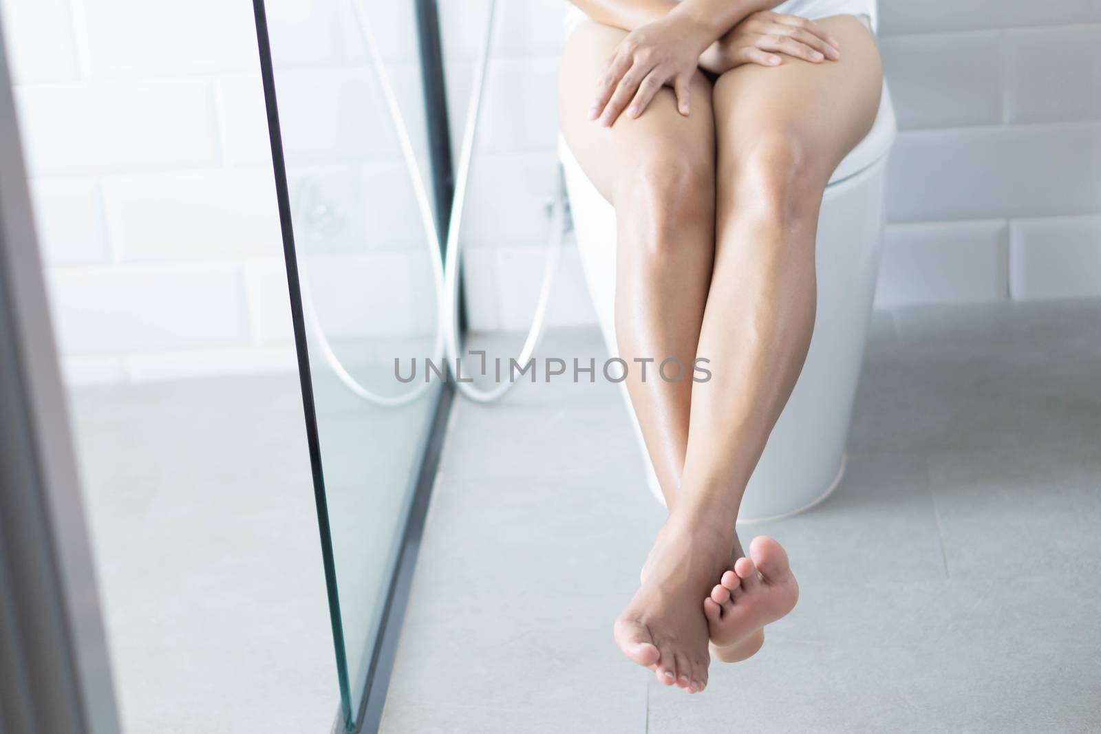 Closeup woman sitting on toilet in the morning, selective focus