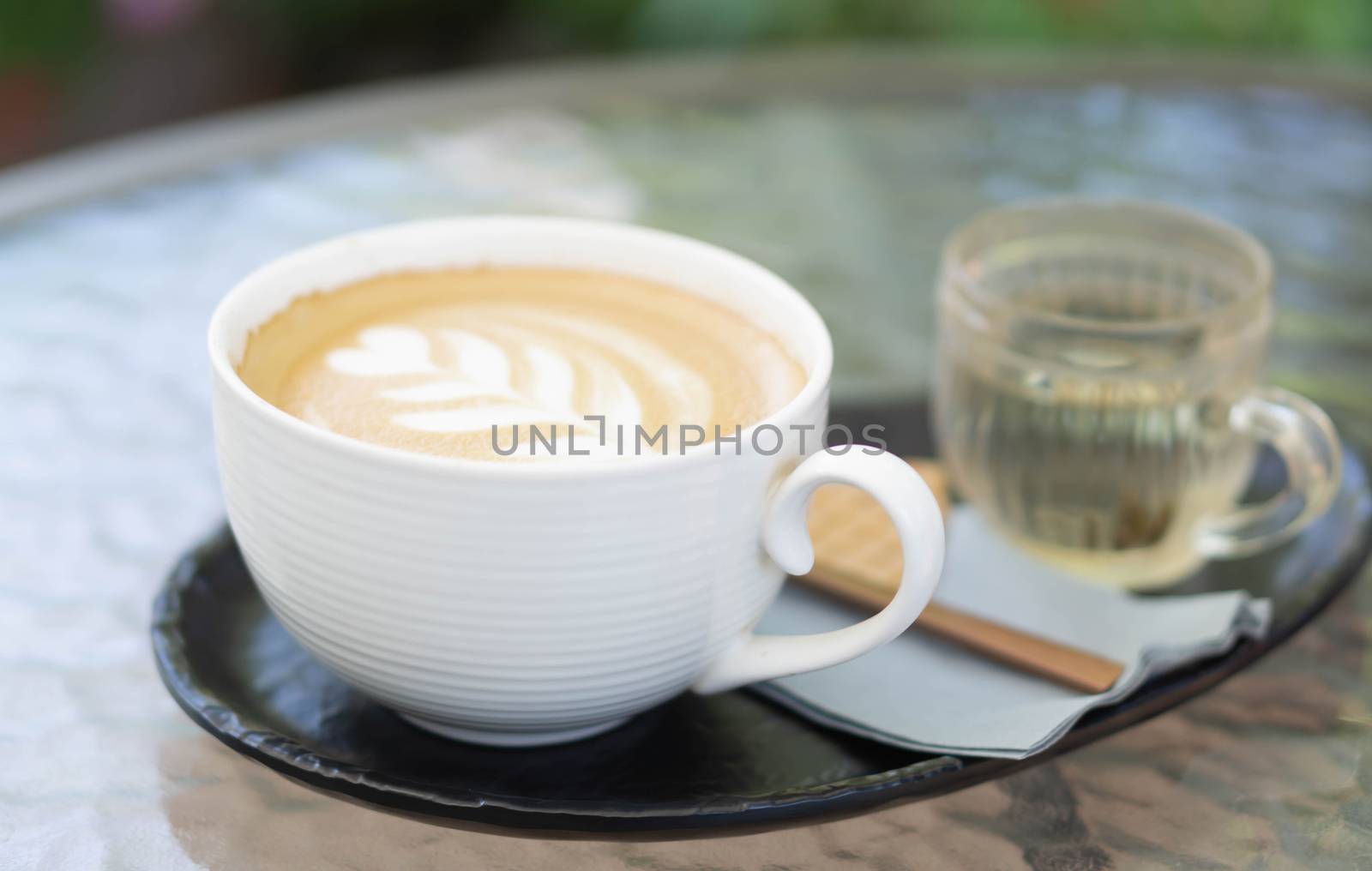 Closeup glass of latte art coffee tulip shape on wood background with vintage color, selective focus