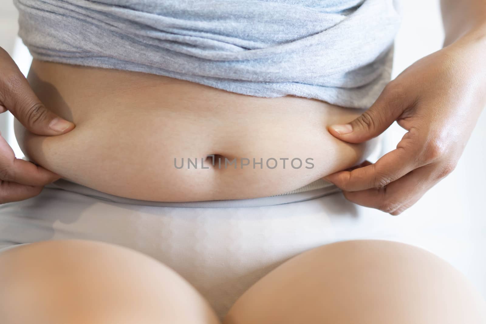 Closeup hand holding abdominal surface woman fat, healthy care and beauty concept