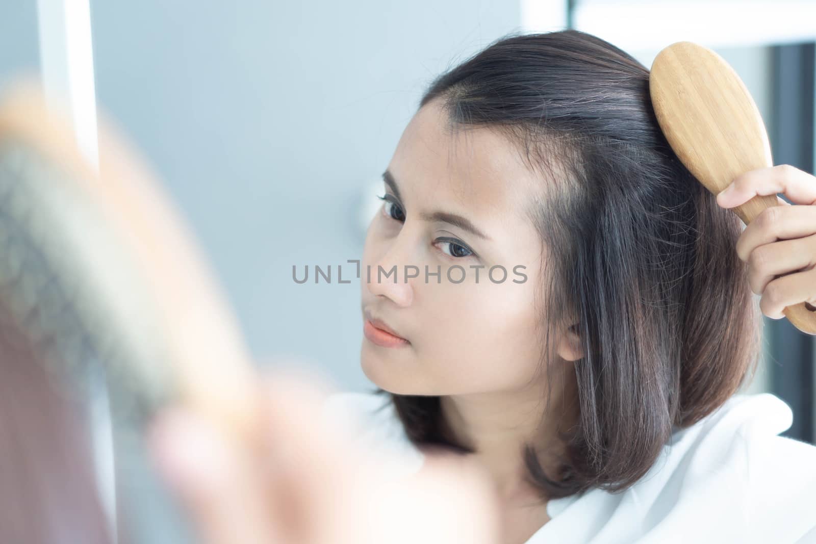 Woman looking reflection in the mirror serious hair loss problem by pt.pongsak@gmail.com