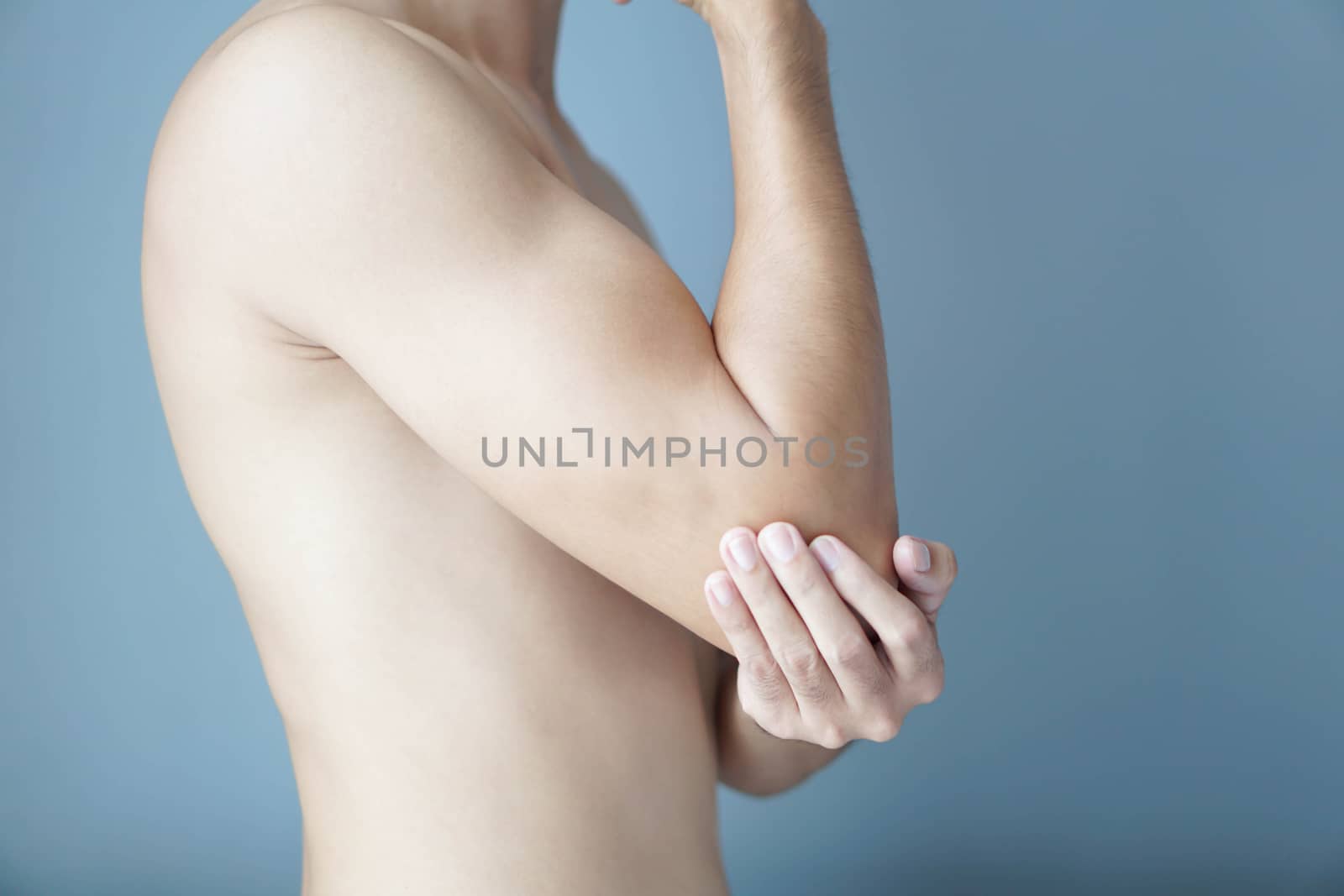 Closeup man hand holding elbow with pain with blue background, h by pt.pongsak@gmail.com