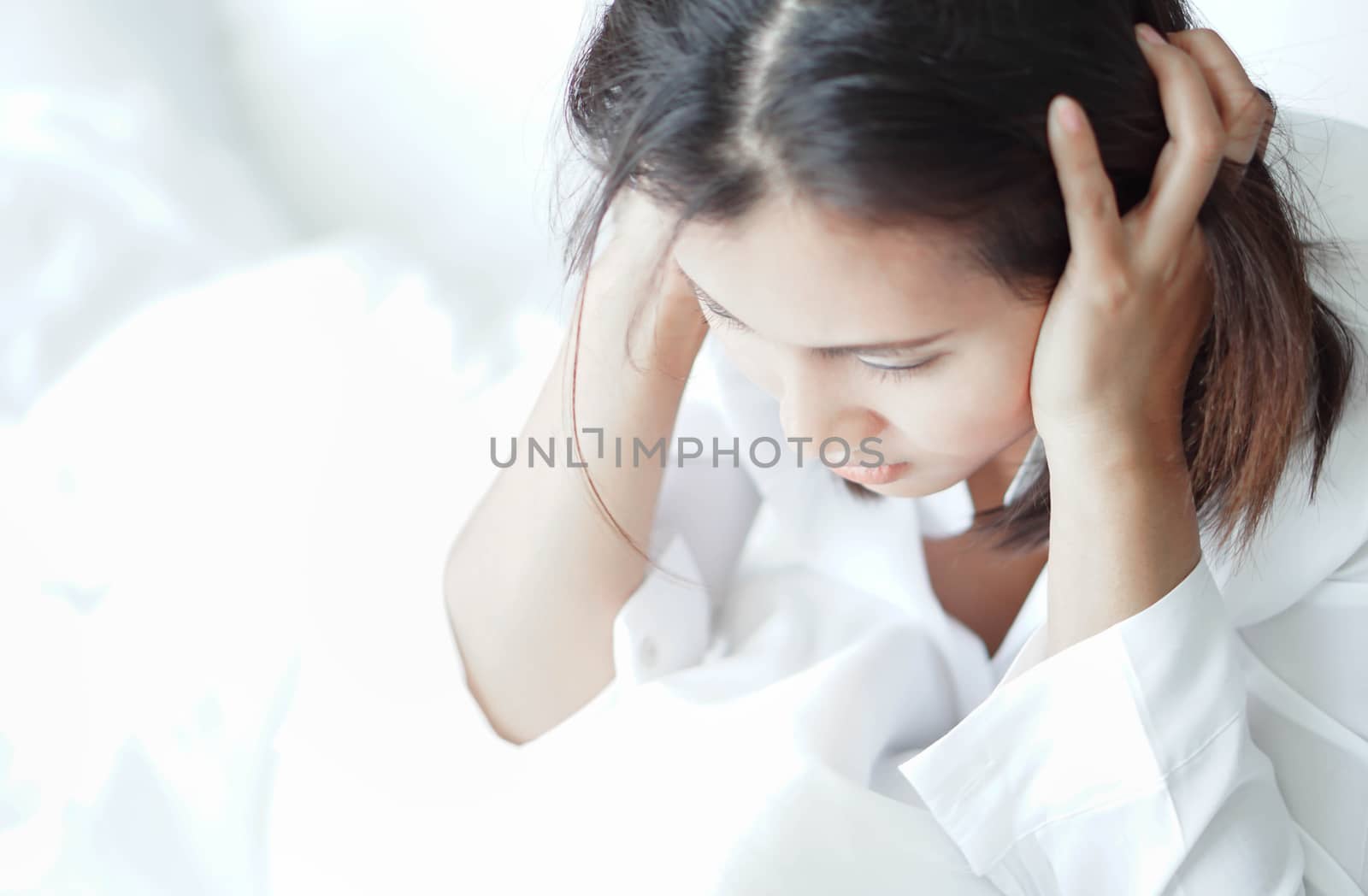 Closeup woman sitting on bed in the bedroom with thinking or depressed feeling, selective focus