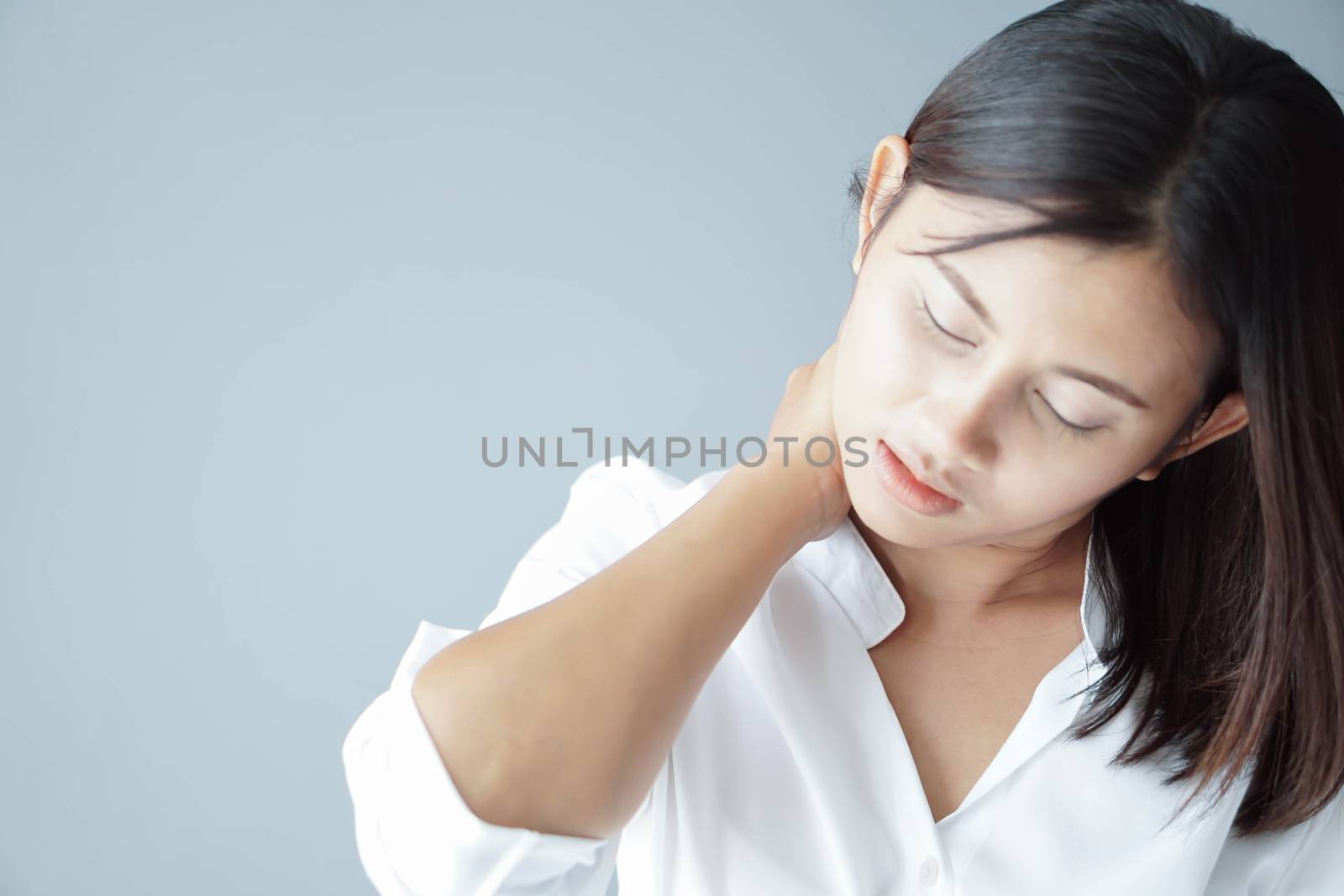 Closeup woman holding neck with pain after waking up on bed, healthy care and medical concept