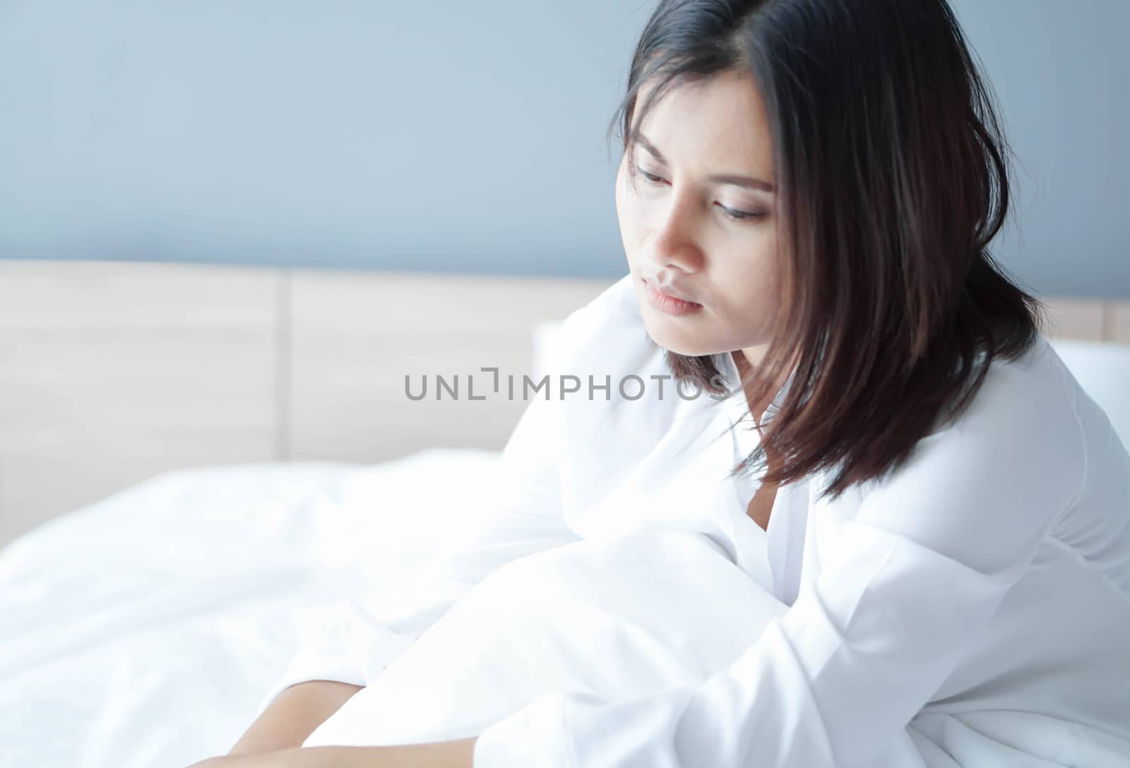 Closeup woman sitting on bed in the bedroom with depressed feeling, selective focus