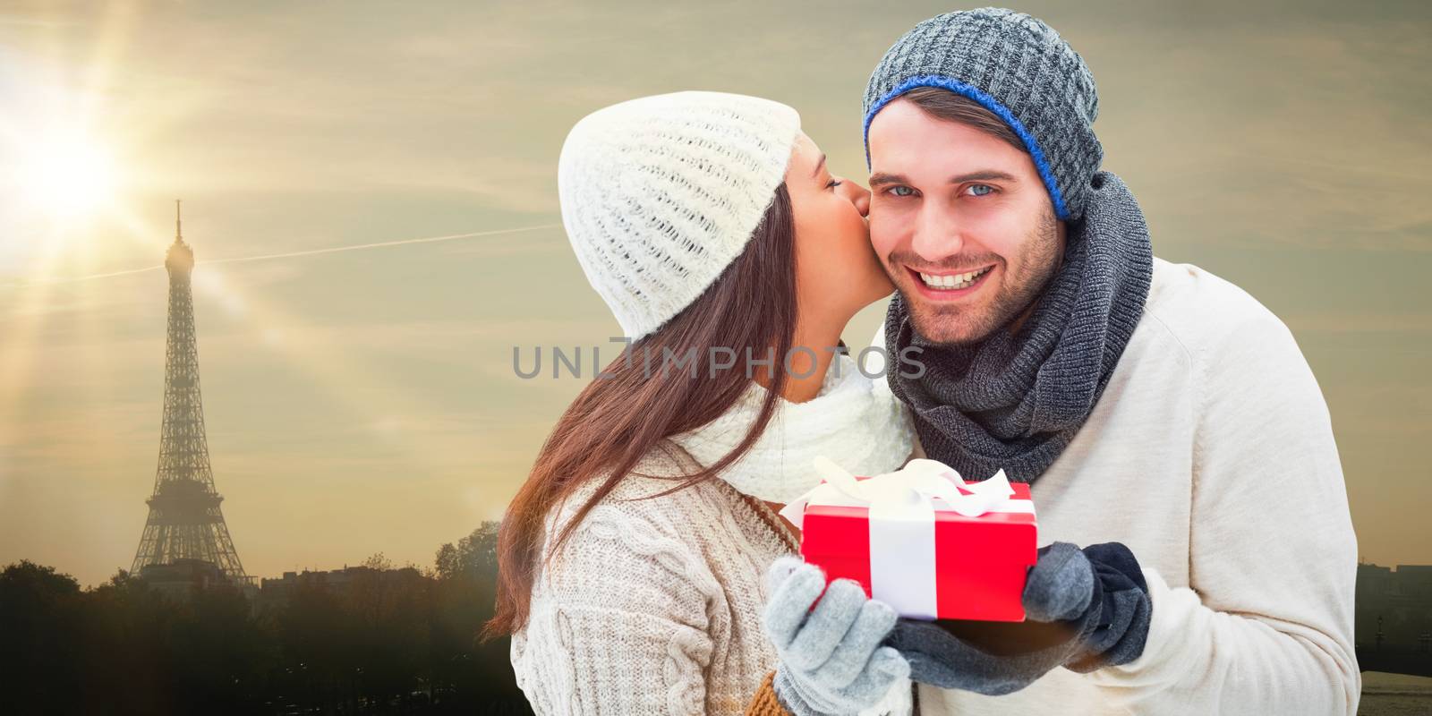 Composite image of winter couple holding gift by Wavebreakmedia