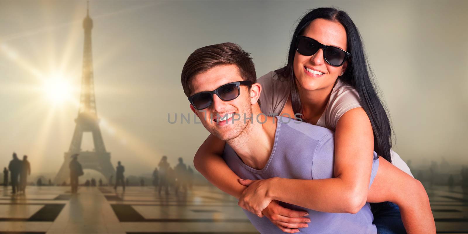 Man giving his pretty girlfriend a piggy back against eiffel tower