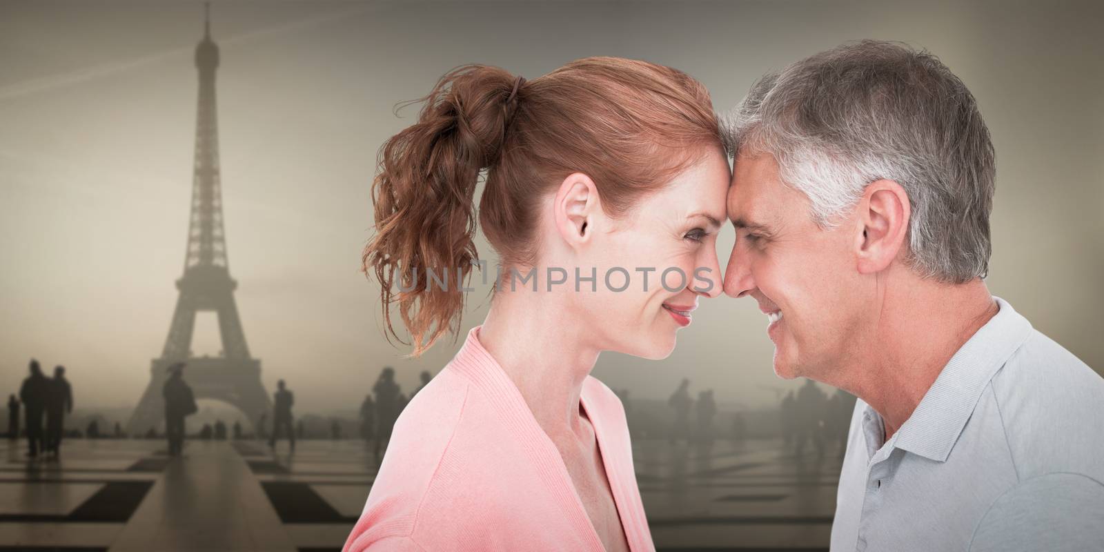 Casual couple smiling at each other against eiffel tower