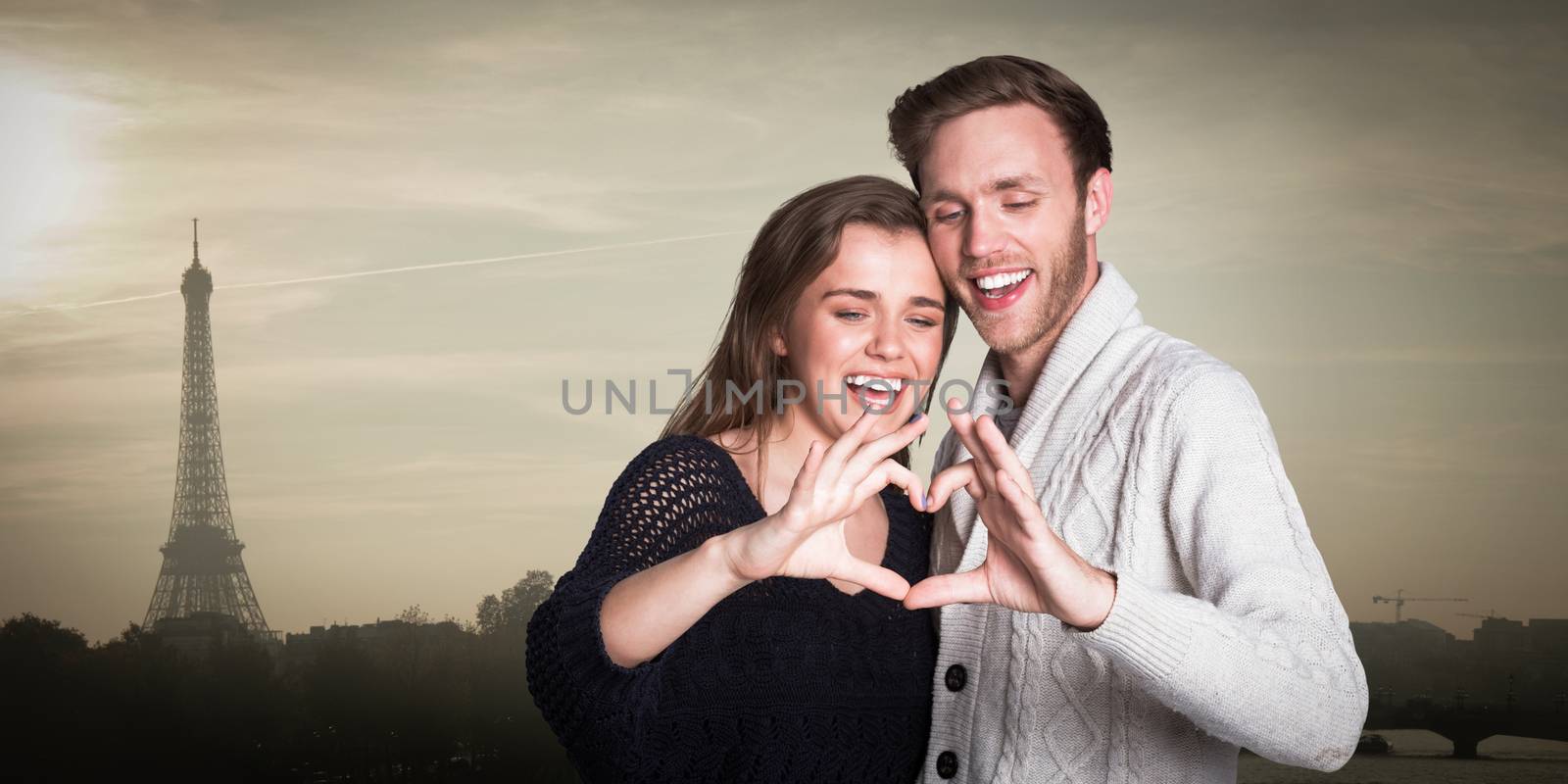 Composite image of happy couple forming heart with hands by Wavebreakmedia