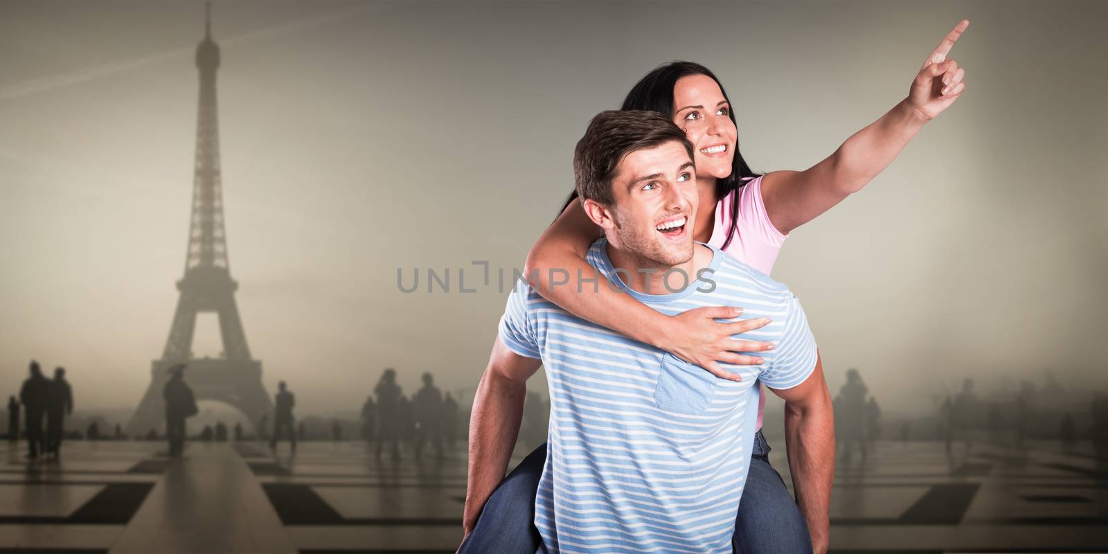 Young man giving girlfriend a piggyback ride against eiffel tower