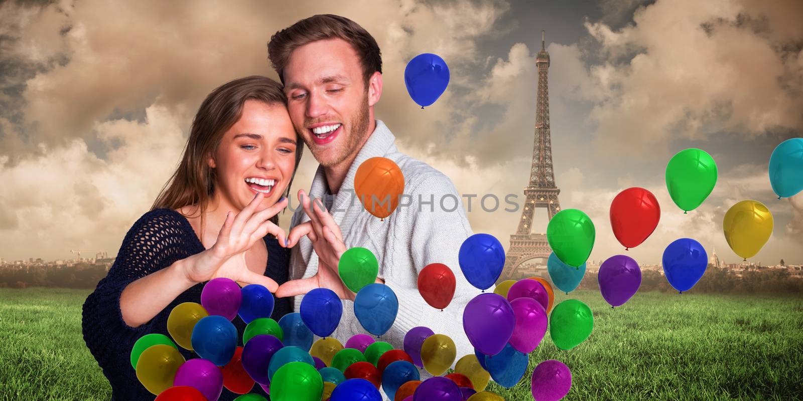 Happy couple forming heart with hands against paris under cloudy sky