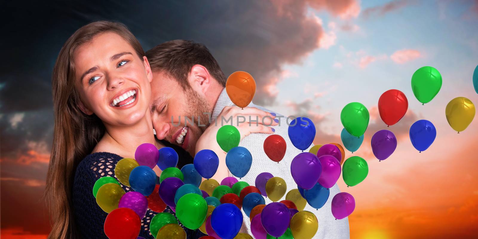 Close up of happy young couple against orange and blue sky with clouds