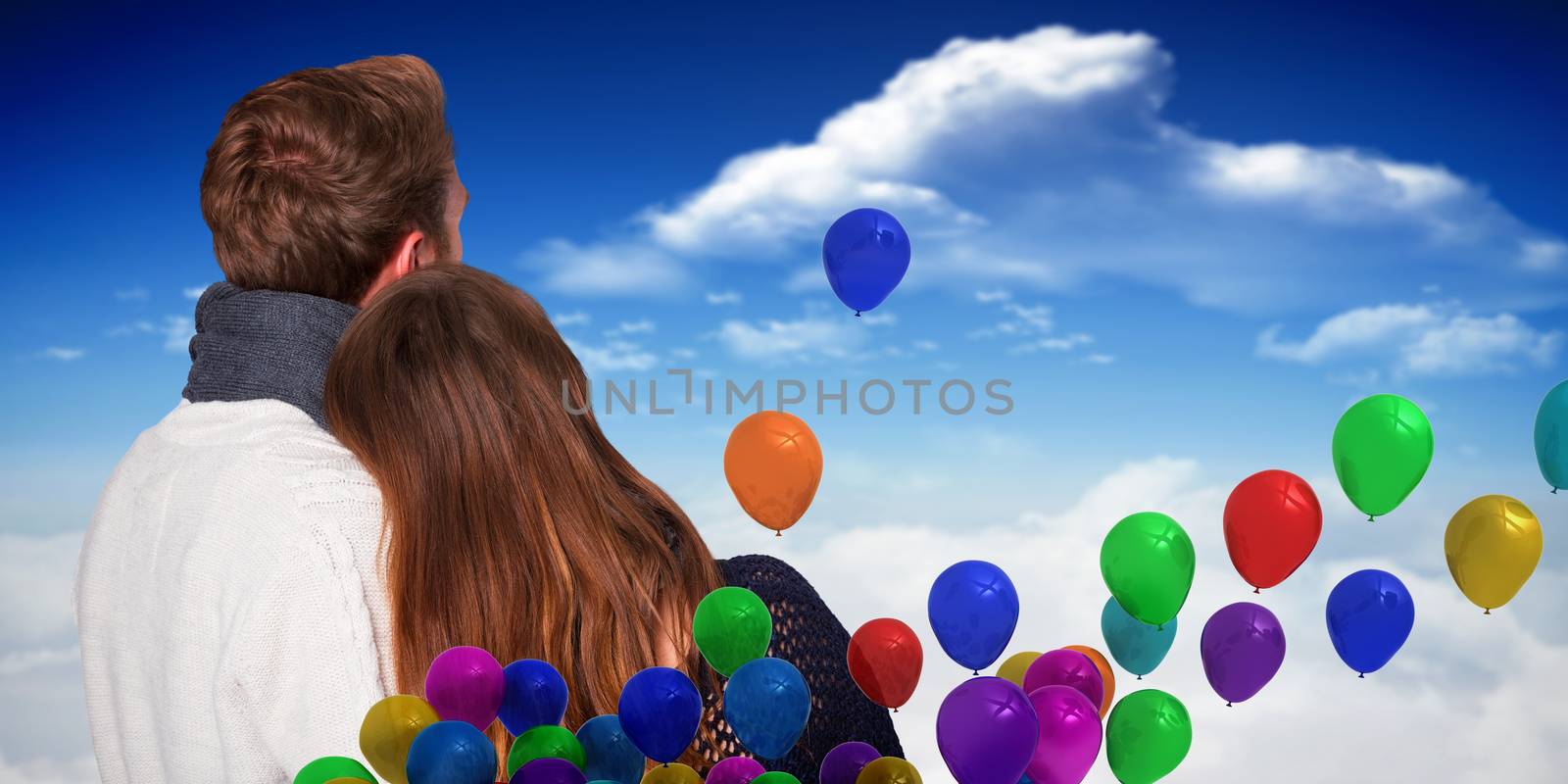 Close up rear view of romantic couple against bright blue sky with clouds
