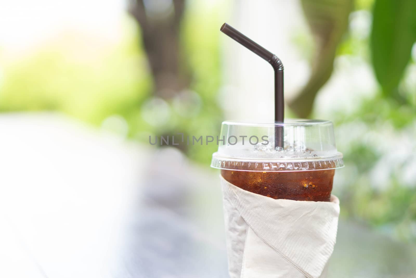 Close up glass of ice americano coffee on wood table, selective focus