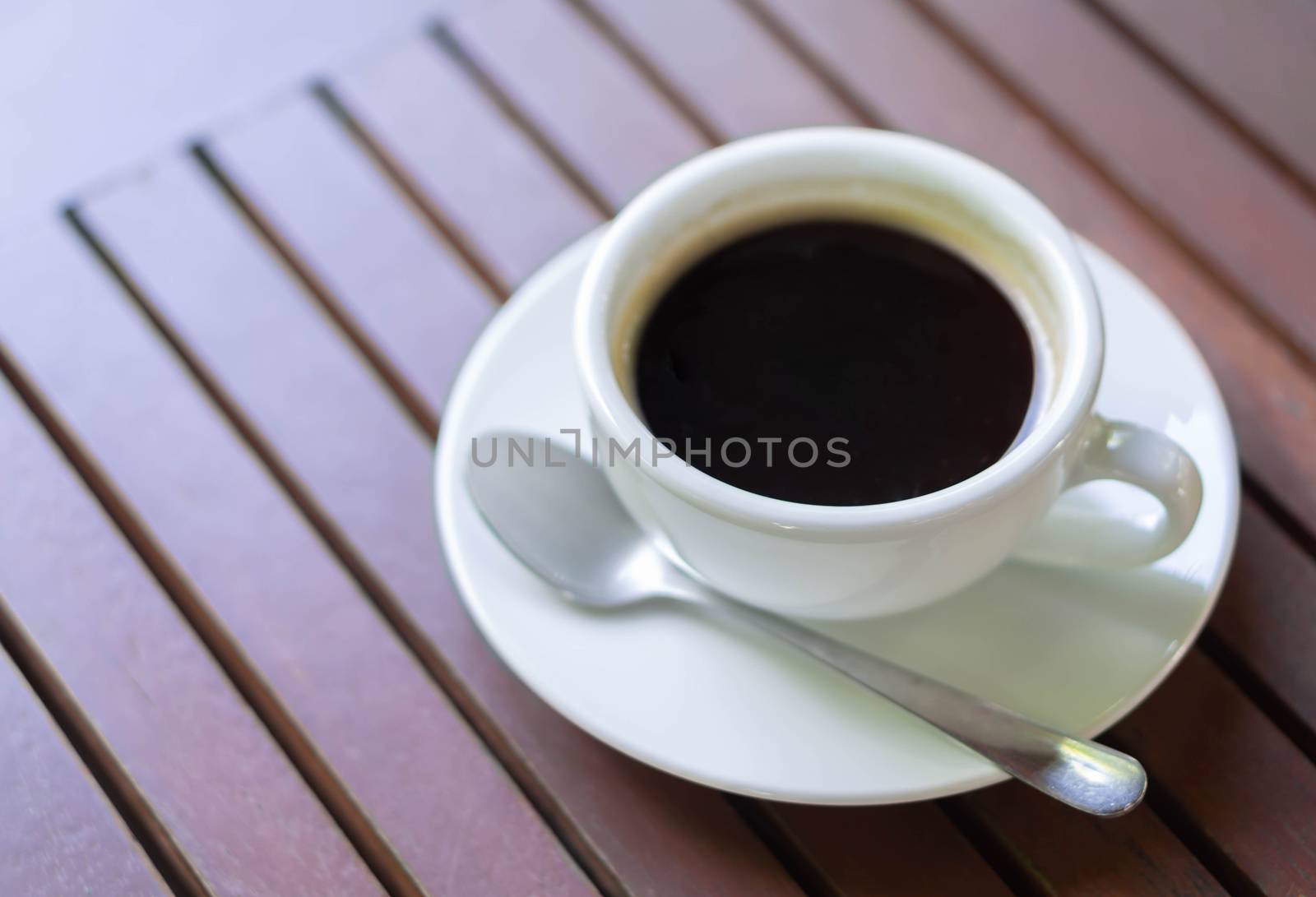 Closeup glass of hot americano coffee on wood table, selective focus, vintage tone