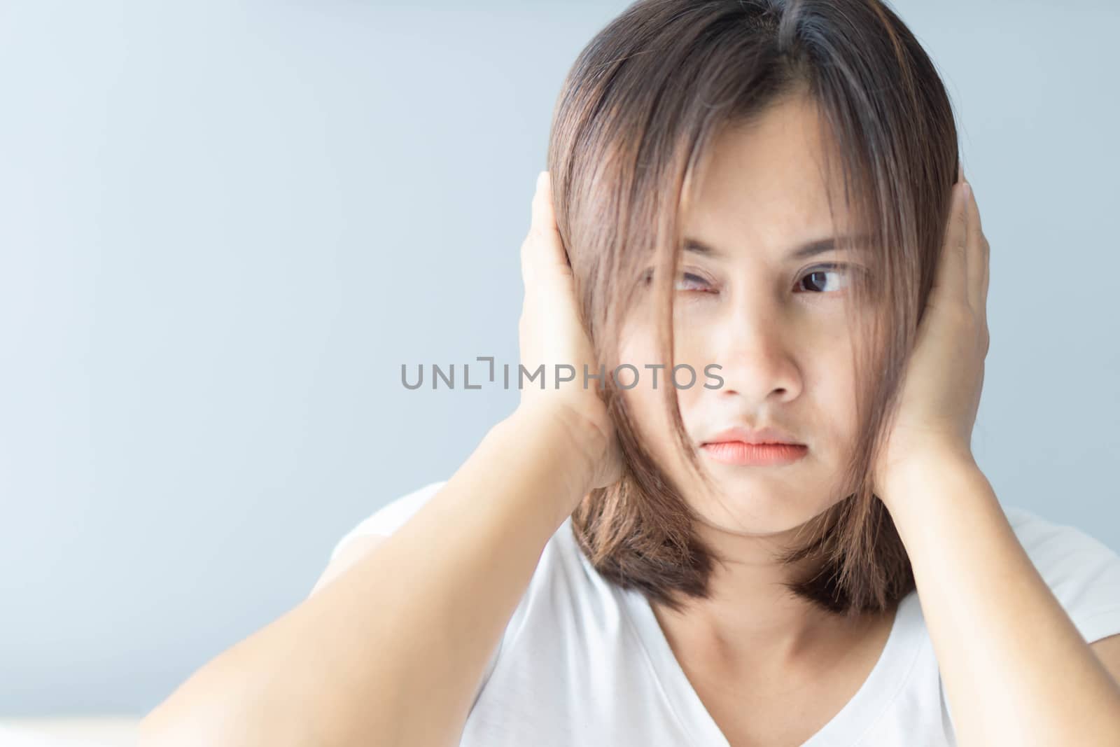 Closeup woman covering ears with her hand, noise problem, selective focus