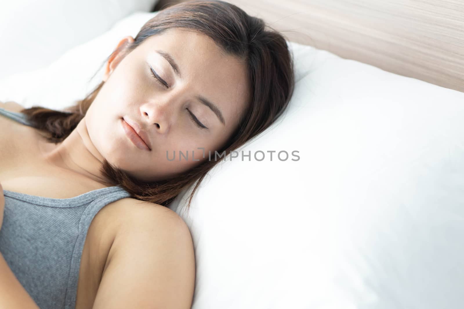 Closeup young woman sleeping with happy face on the bed, selective focus