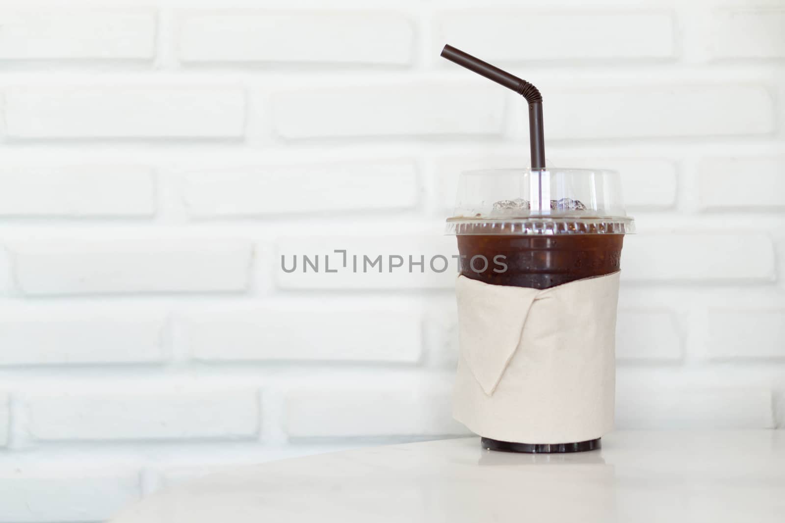 Close up glass of ice americano coffee on wood table, selective focus