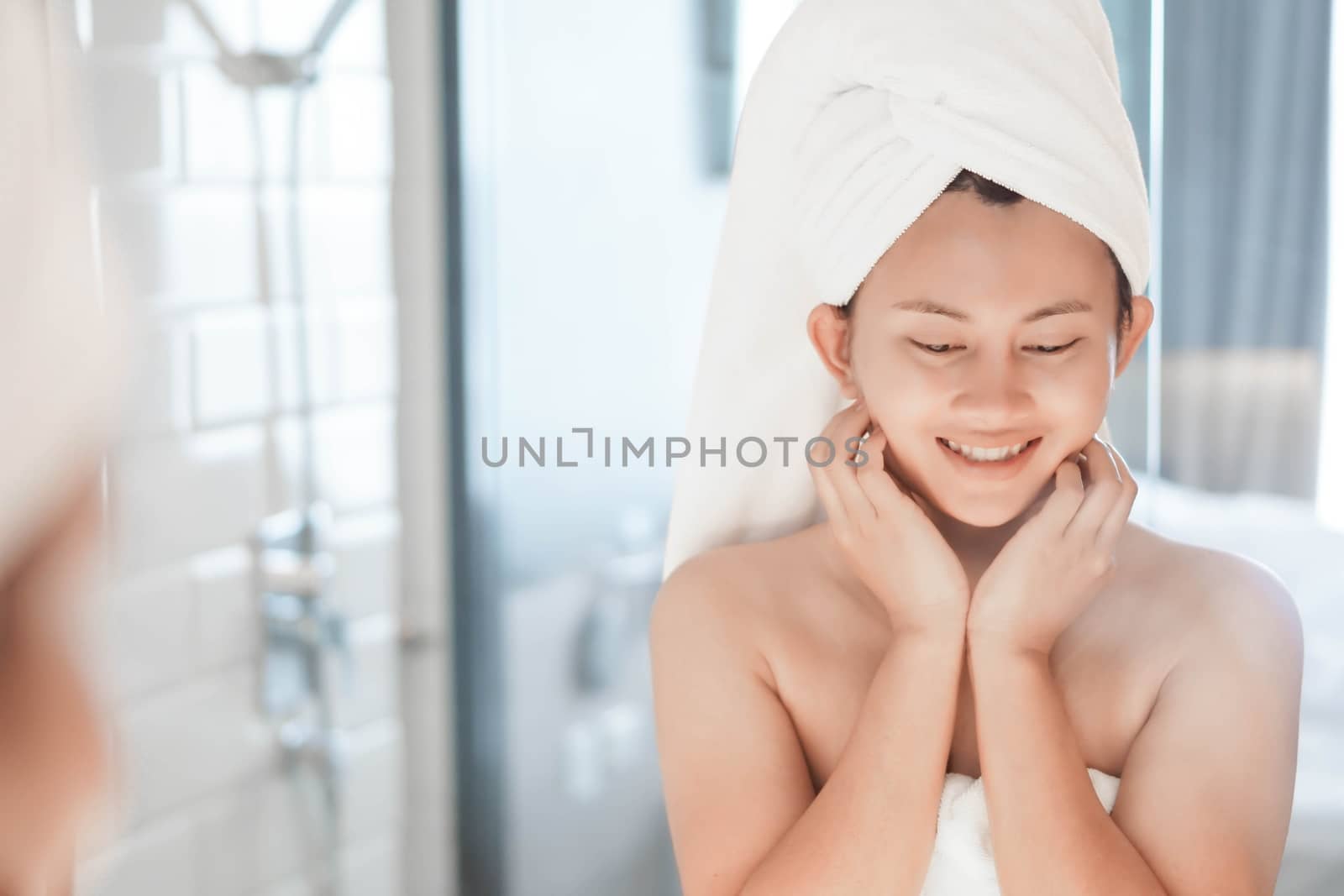 Close up woman looking her face in the mirror with smiling after bath, health care and beauty