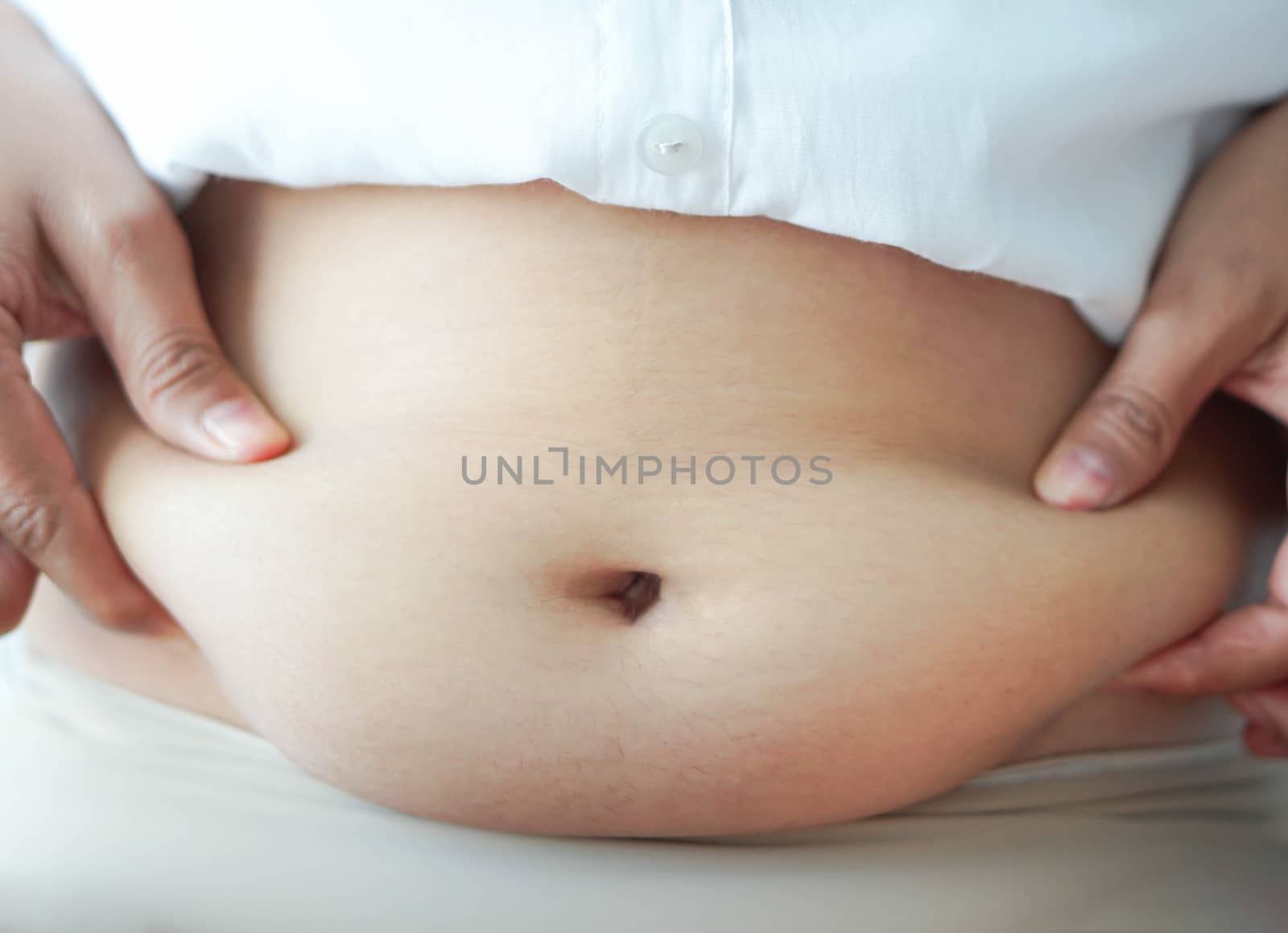 Closeup hand holding abdominal surface woman fat, healthy care and beauty concept