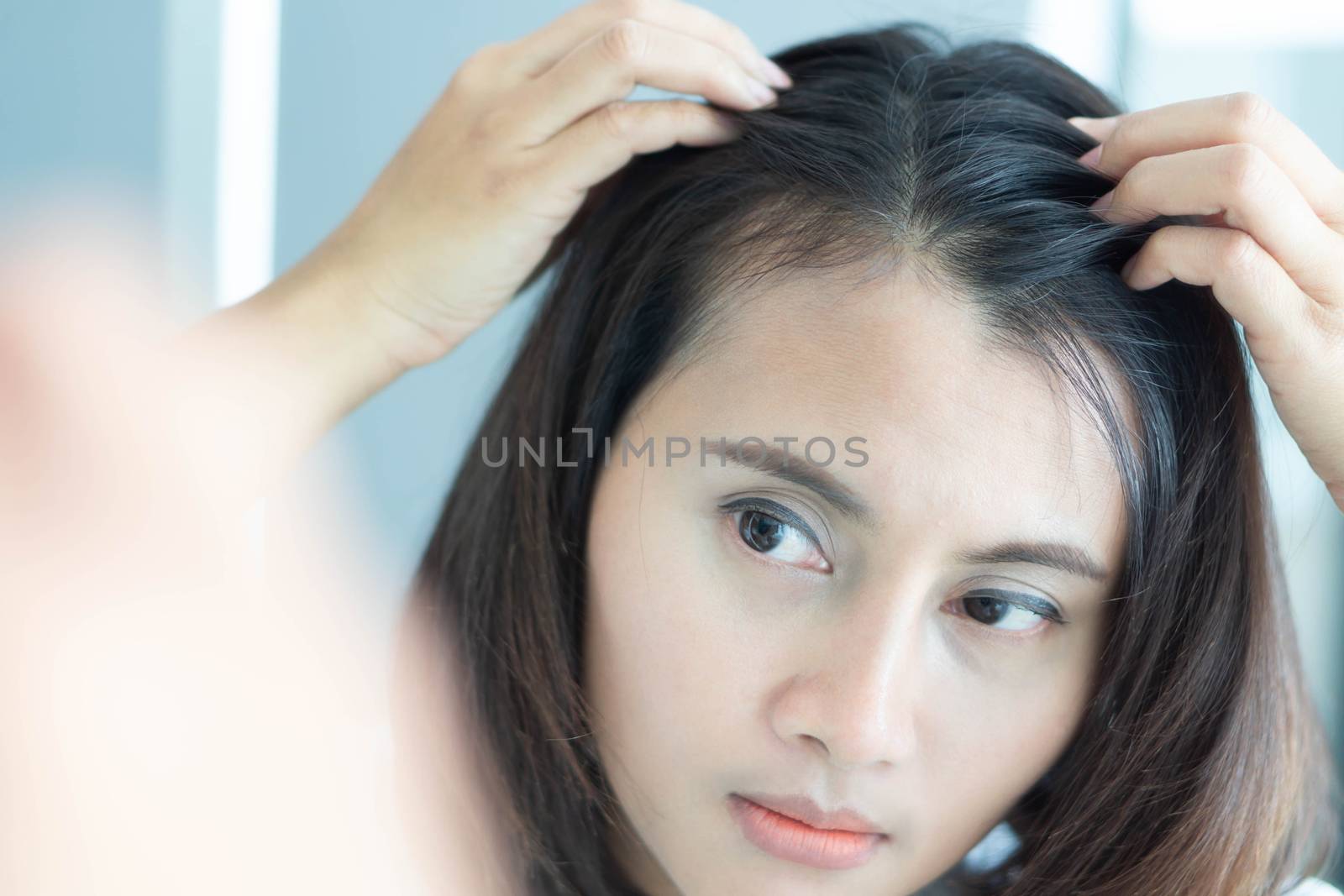 Woman looking reflection in the mirror serious hair loss problem for health care shampoo and beauty product concept