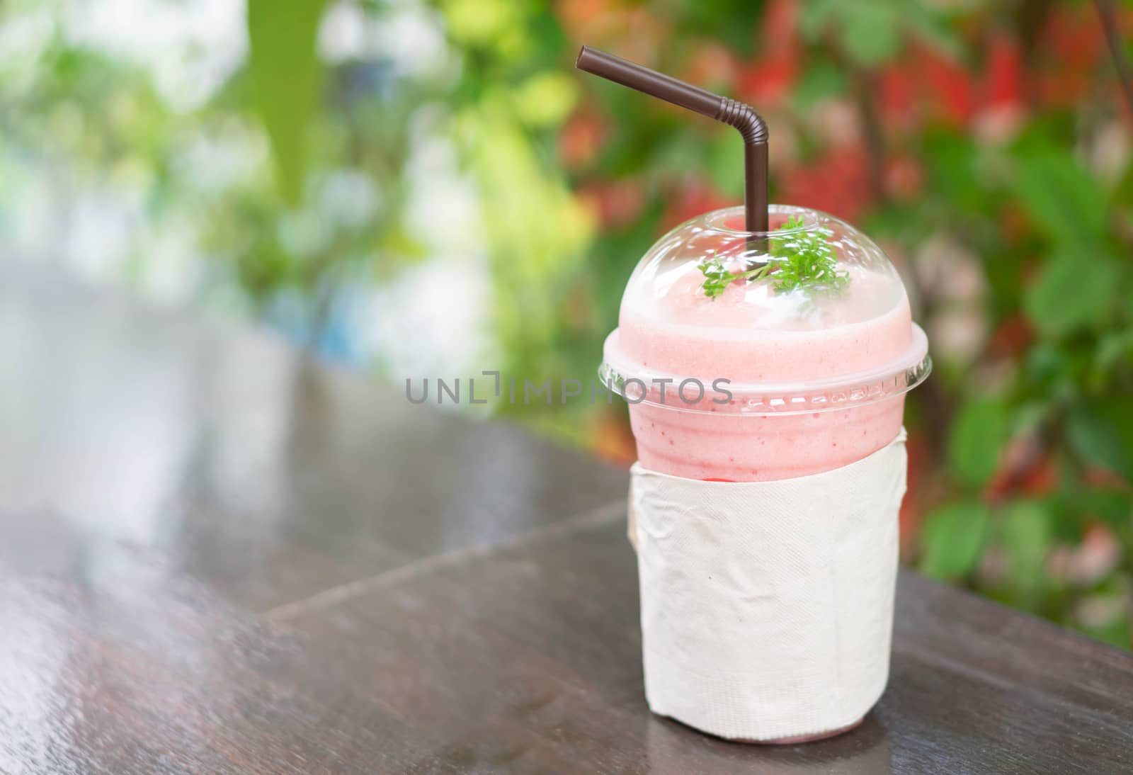 Closeup  strawberry smoothie with green nature background, selective focus