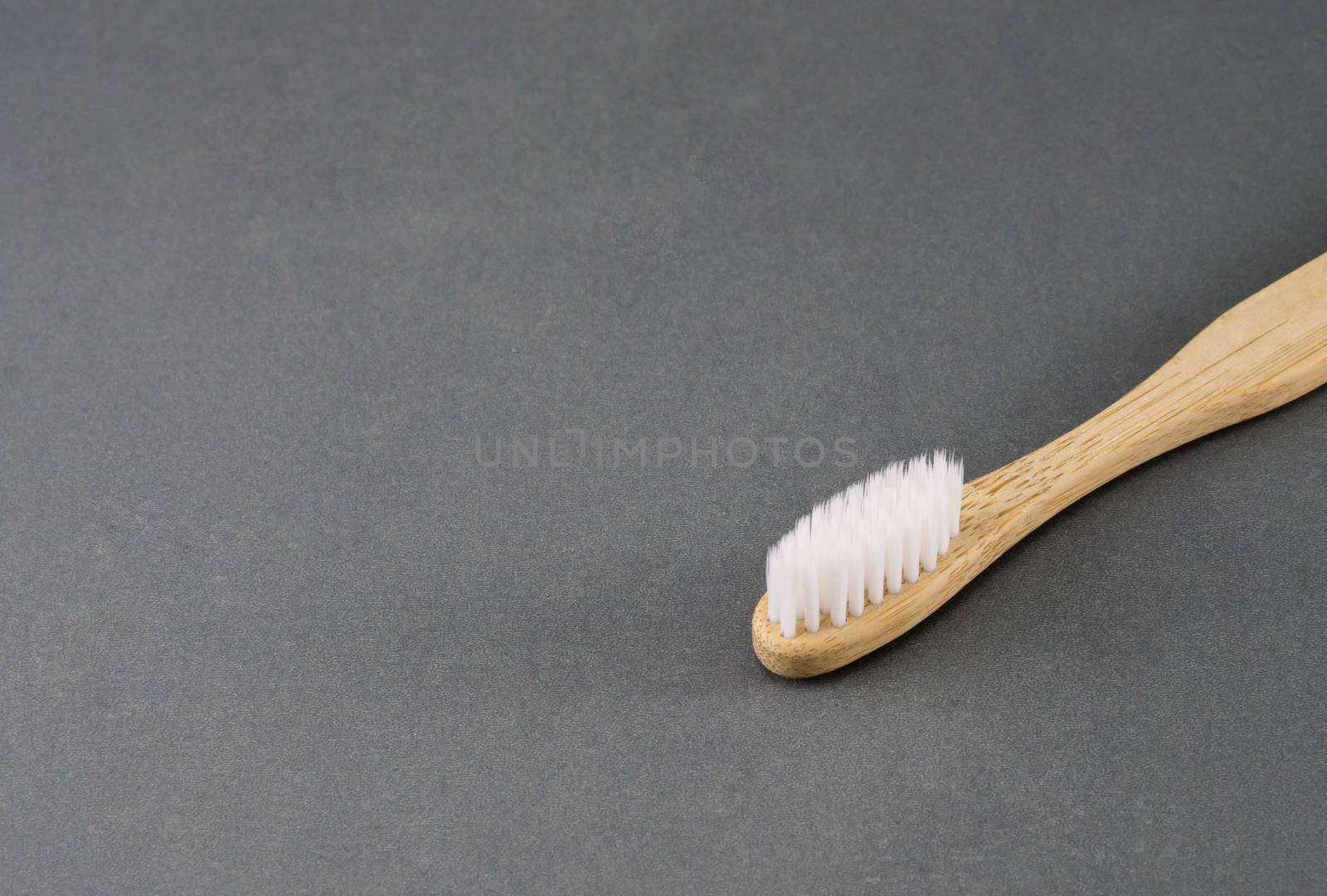 Close up wooden toothbrush on grey background, selective focus by pt.pongsak@gmail.com