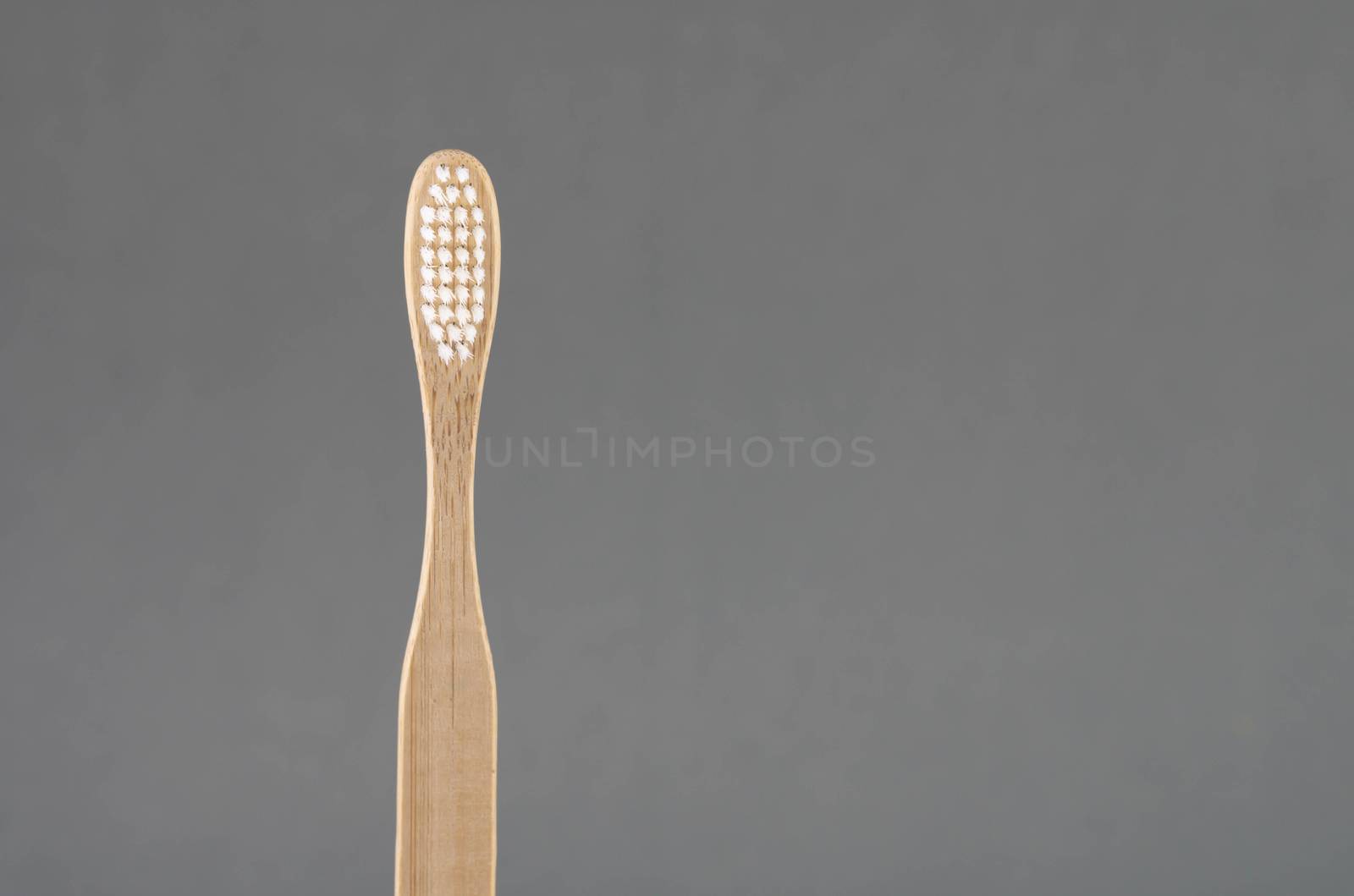 Close up wooden toothbrush on grey background, selective focus by pt.pongsak@gmail.com