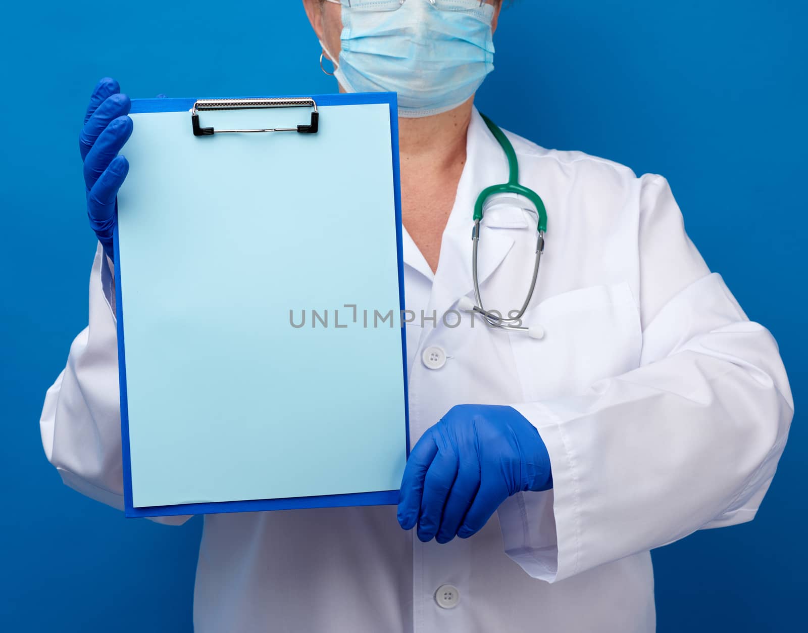 female doctor dressed in a white medical gown and blue latex glo by ndanko